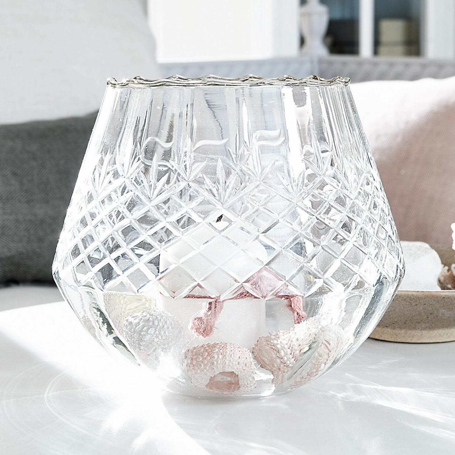 Windlicht Tianie Glas-Teelichthalter mit graviertem Muster, weißer Kerze und Muscheldekor auf Tisch