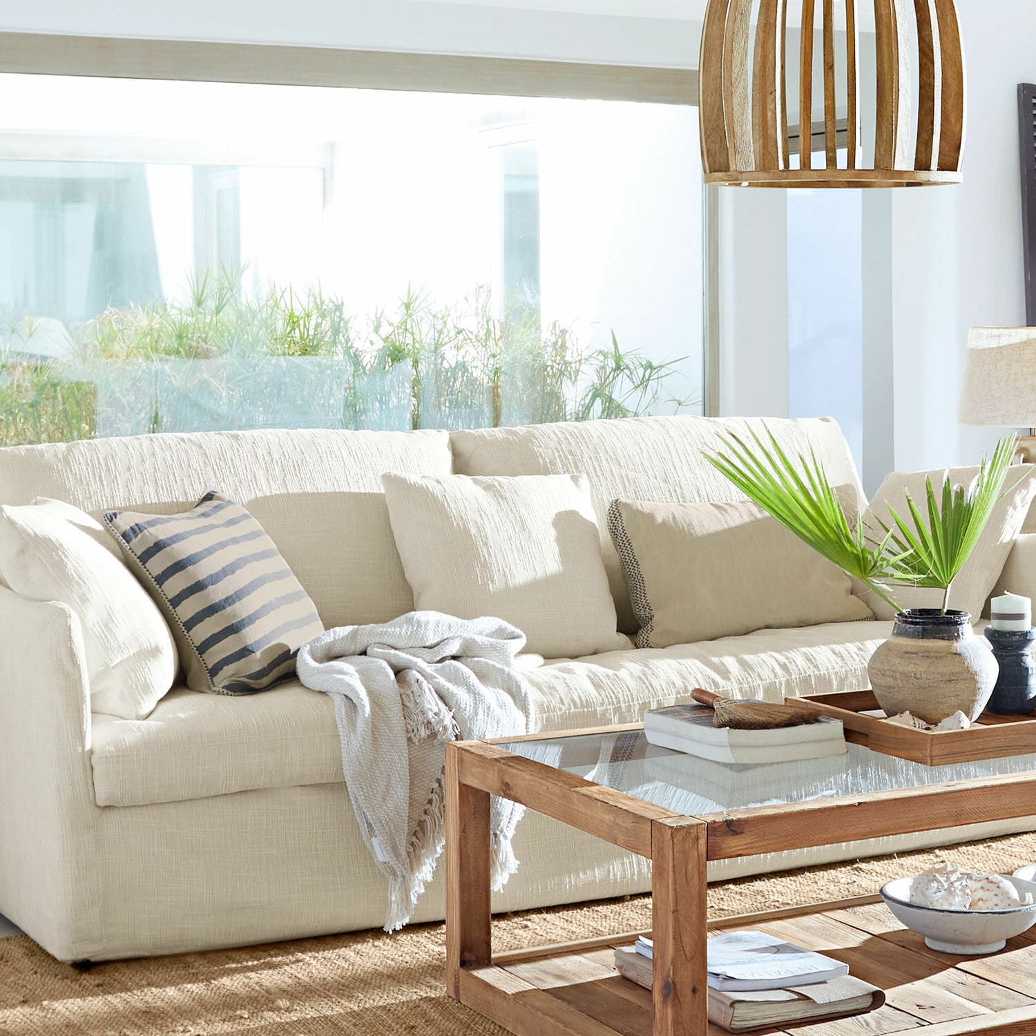 Beige Stoffsofa mit Kissen und Holzcouchtisch in hellem Wohnzimmer