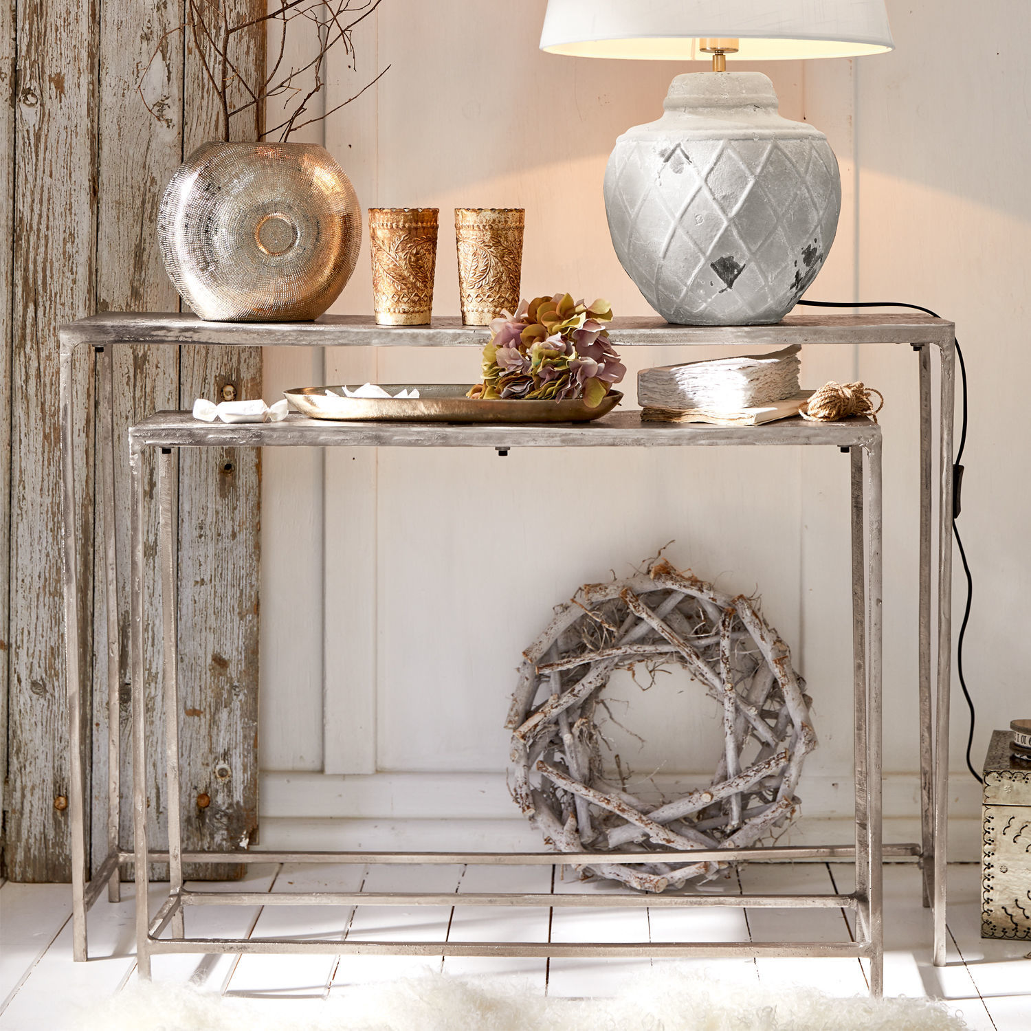 Zwei graue Metall-Nestingtische im Used-Look mit Vintage-Deko und weißer Tischlampe