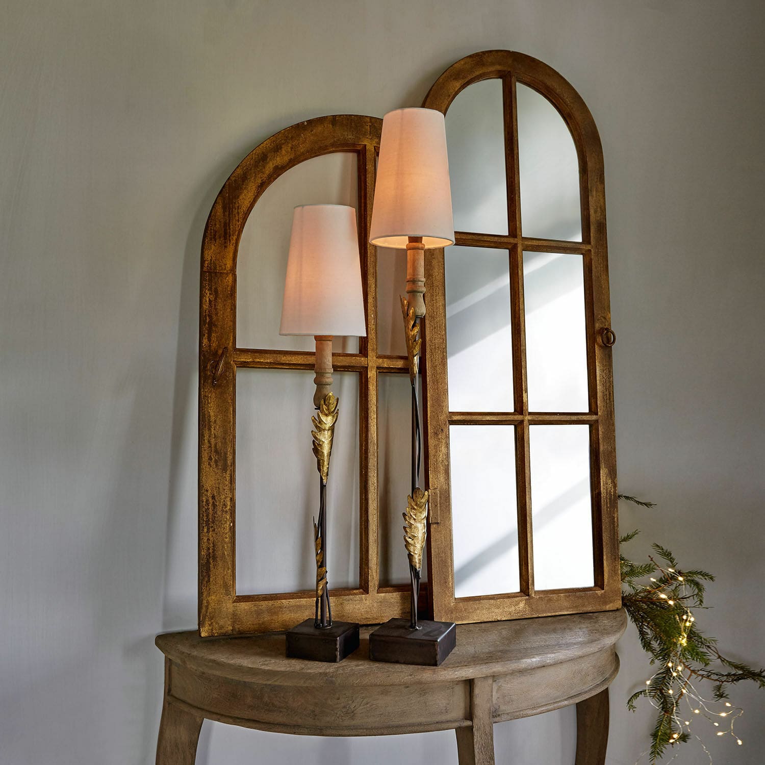 Holztisch mit zwei goldenen Spiegeln und Lampen mit weißen Schirmen im Vintage-Stil