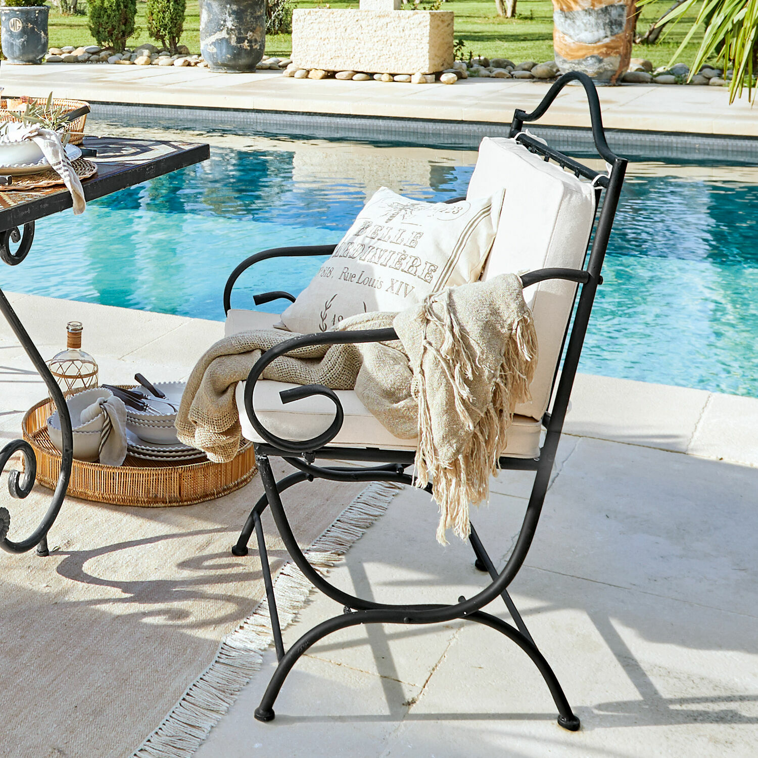 Stuhl Avanton Schwarzer Metall-Gartenstuhl mit cremefarbenem Kissen und beiger Decke am Pool, Gartenmöbel
