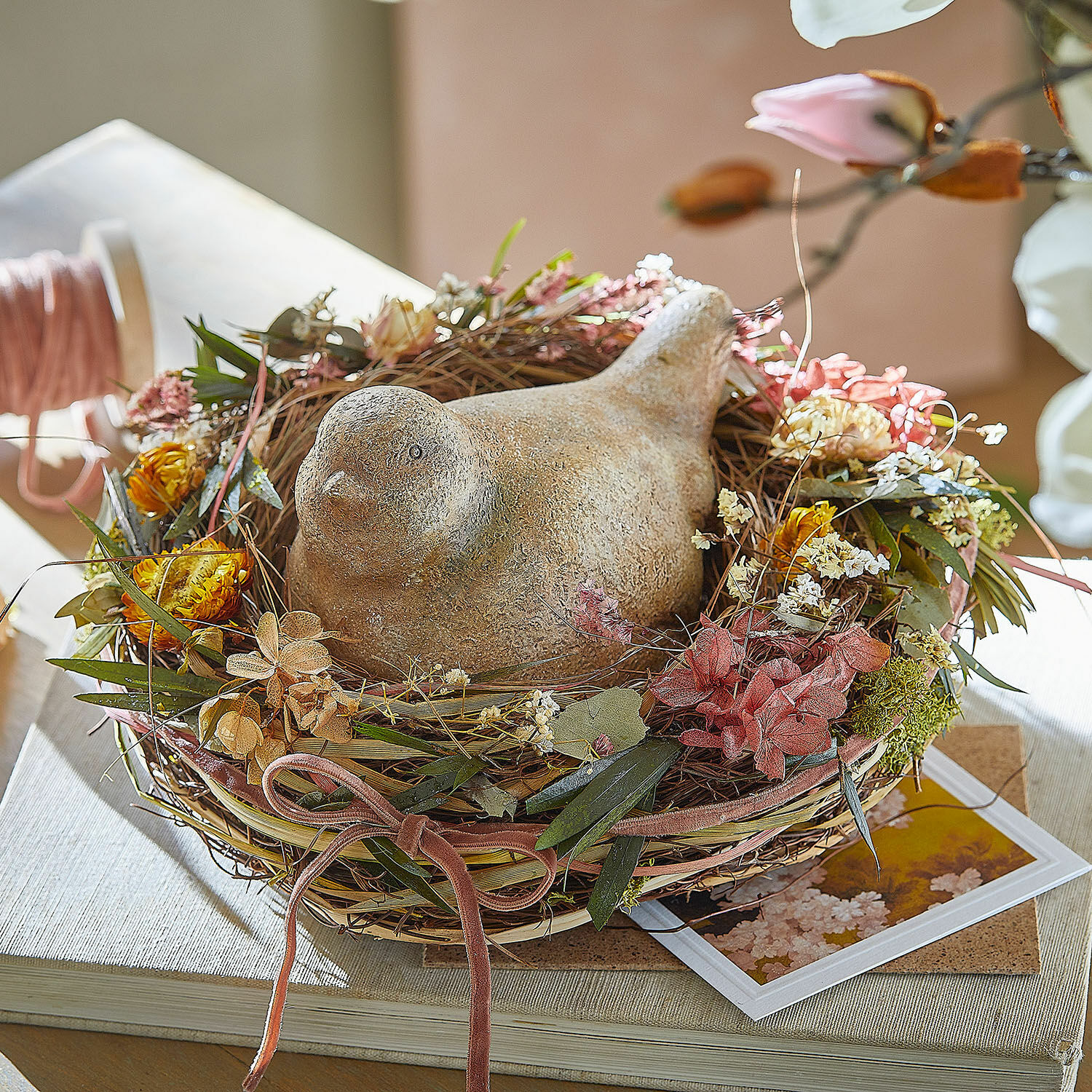 Nest Bravilex Dekorativer Keramikvogel im Nest aus getrockneten Blumen und Blättern auf Tisch