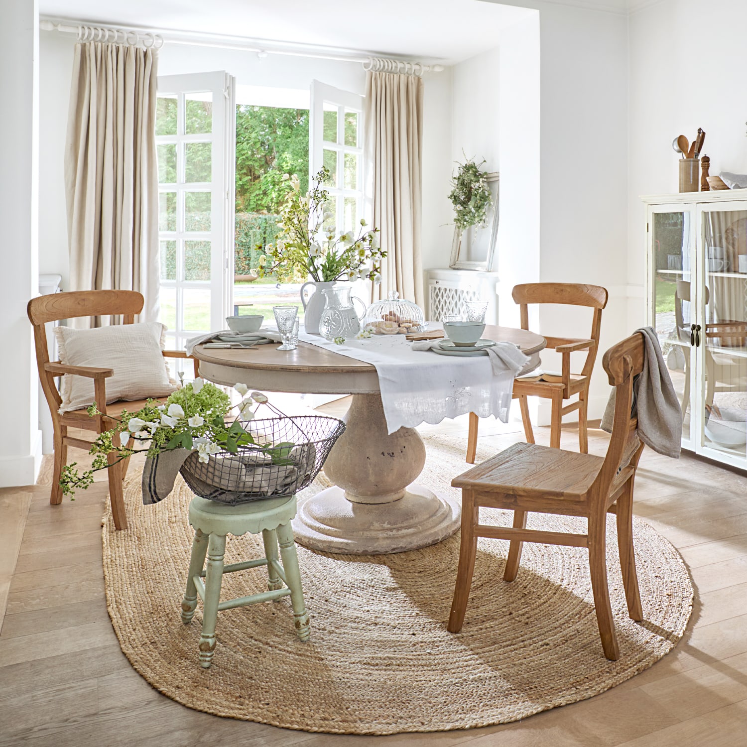 Esszimmer mit rundem Steintisch und Holzstühlen auf rundem Juteteppich