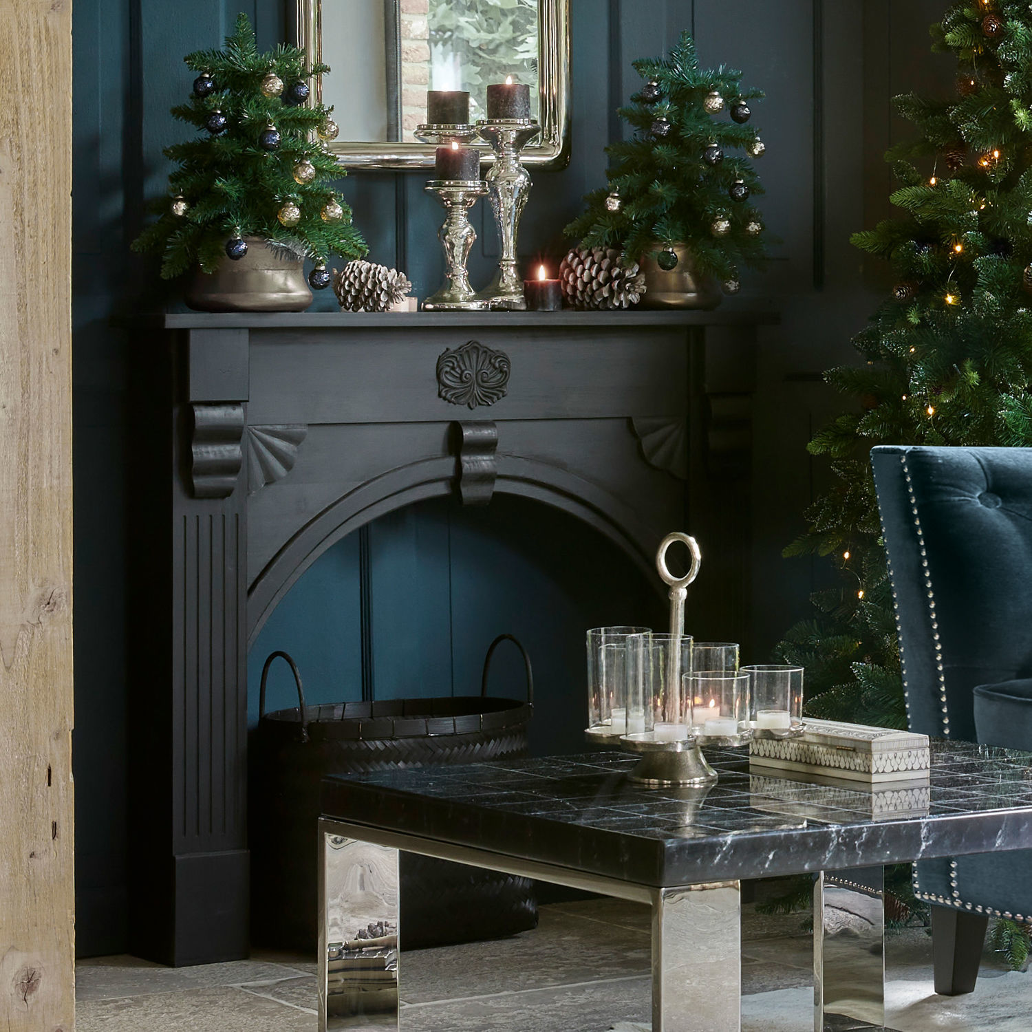 Schwarzer dekorativer Holz-Kamin im klassischen Stil mit Verzierungen und festlicher Weihnachtsdeko