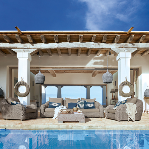 Gartenmöbel-Set aus grauem Rattan mit blauen Kissen am Pool unter Holzüberdachung