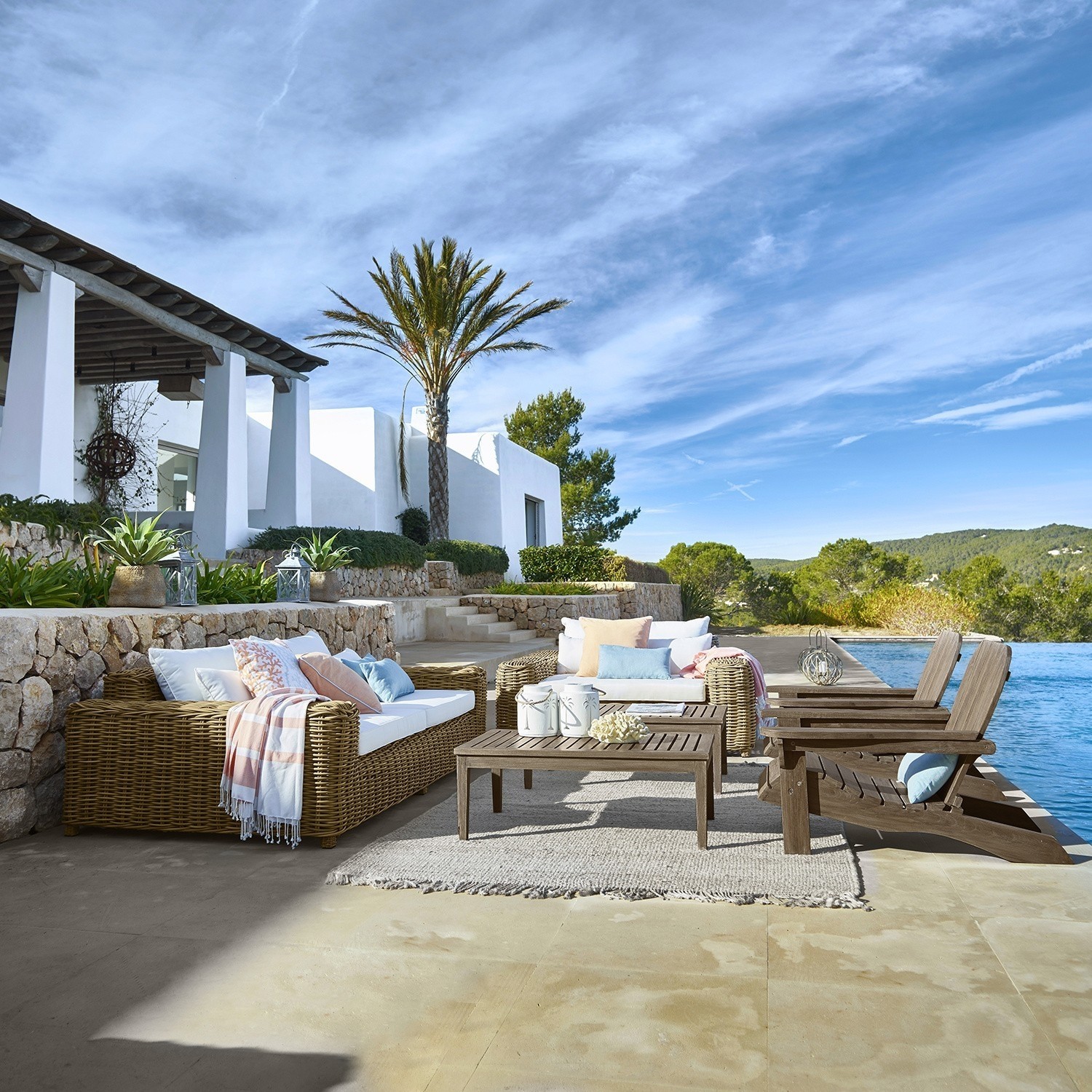 Gartenmöbel-Set aus Rattan und Holz in Naturtönen am Pool auf sonniger Terrasse