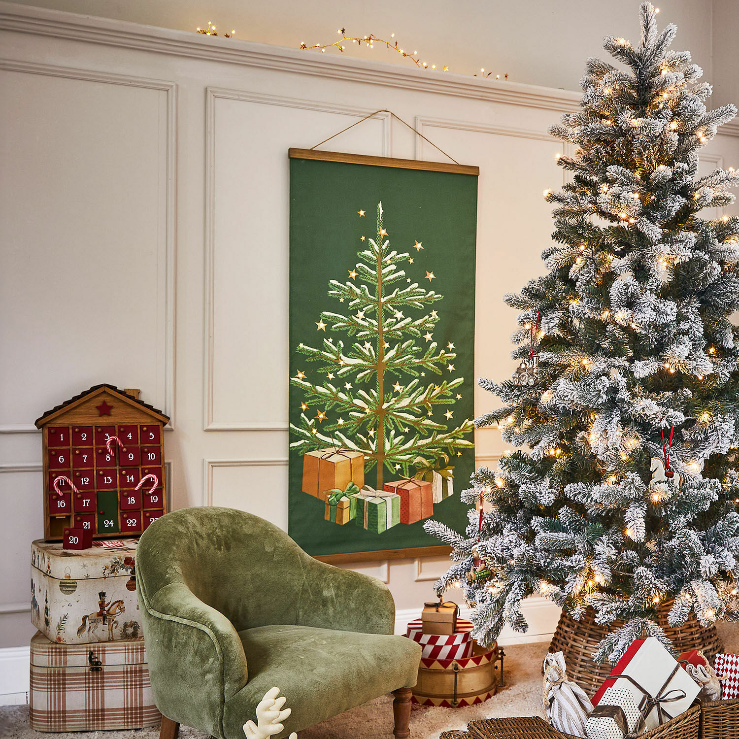 Gemütlicher grüner Sessel neben beleuchtetem Weihnachtsbaum mit Geschenken im Wohnzimmer