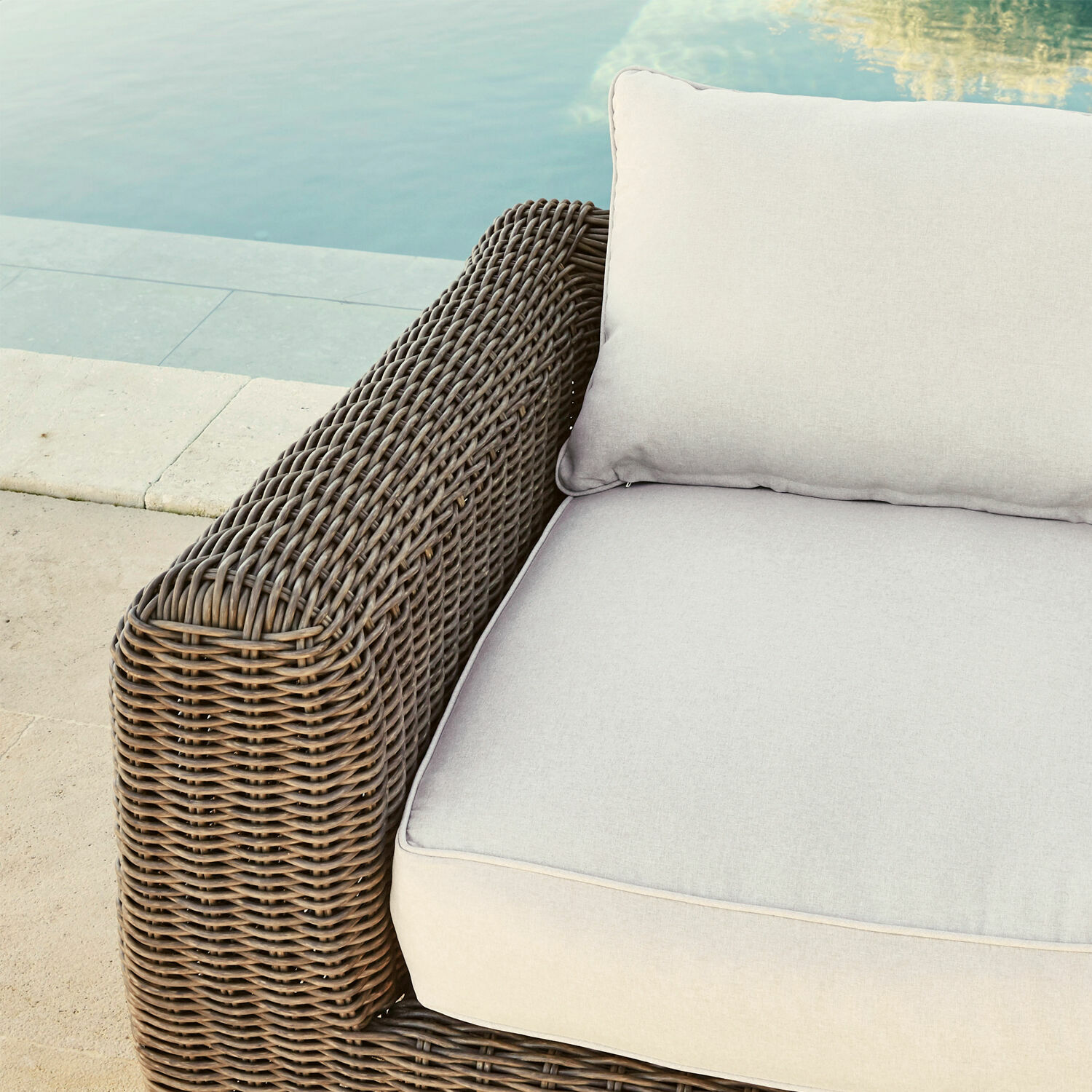 Braunes Rattanmöbel mit hellgrauen Kissen am Pool, bequeme Gartenmöbel mit Polstern