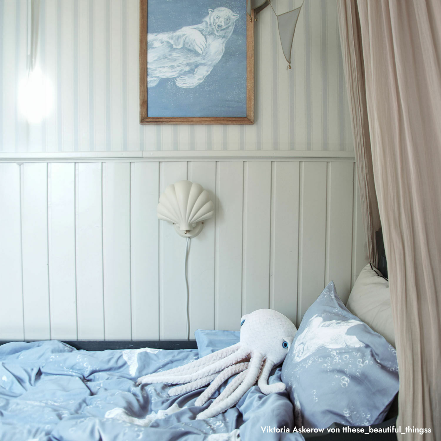 Blaue Bettwäsche mit Unterwasser-Motiv und weißer Plüsch-Oktopus auf Bett in hellem Zimmer
