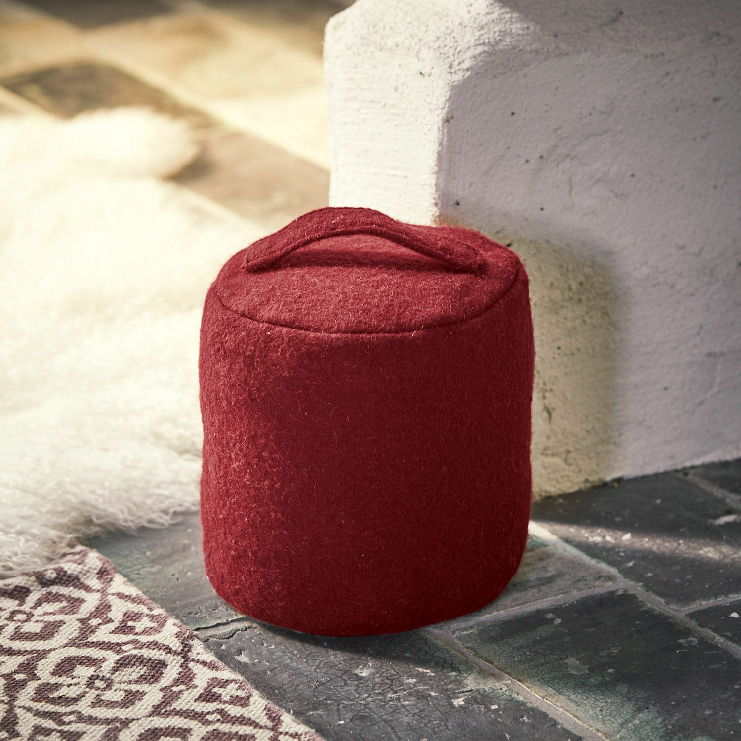Roter Filz-Türstopper mit Griff auf Boden neben Wand, Wohnaccessoire für Innenräume