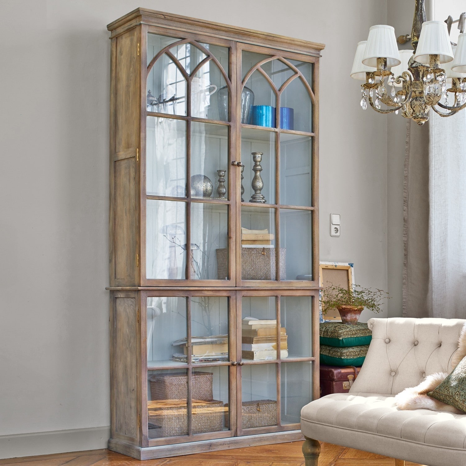Vitrine aus naturfarbenem Holz mit Glastüren und dekorativen Regalen im Wohnzimmer
