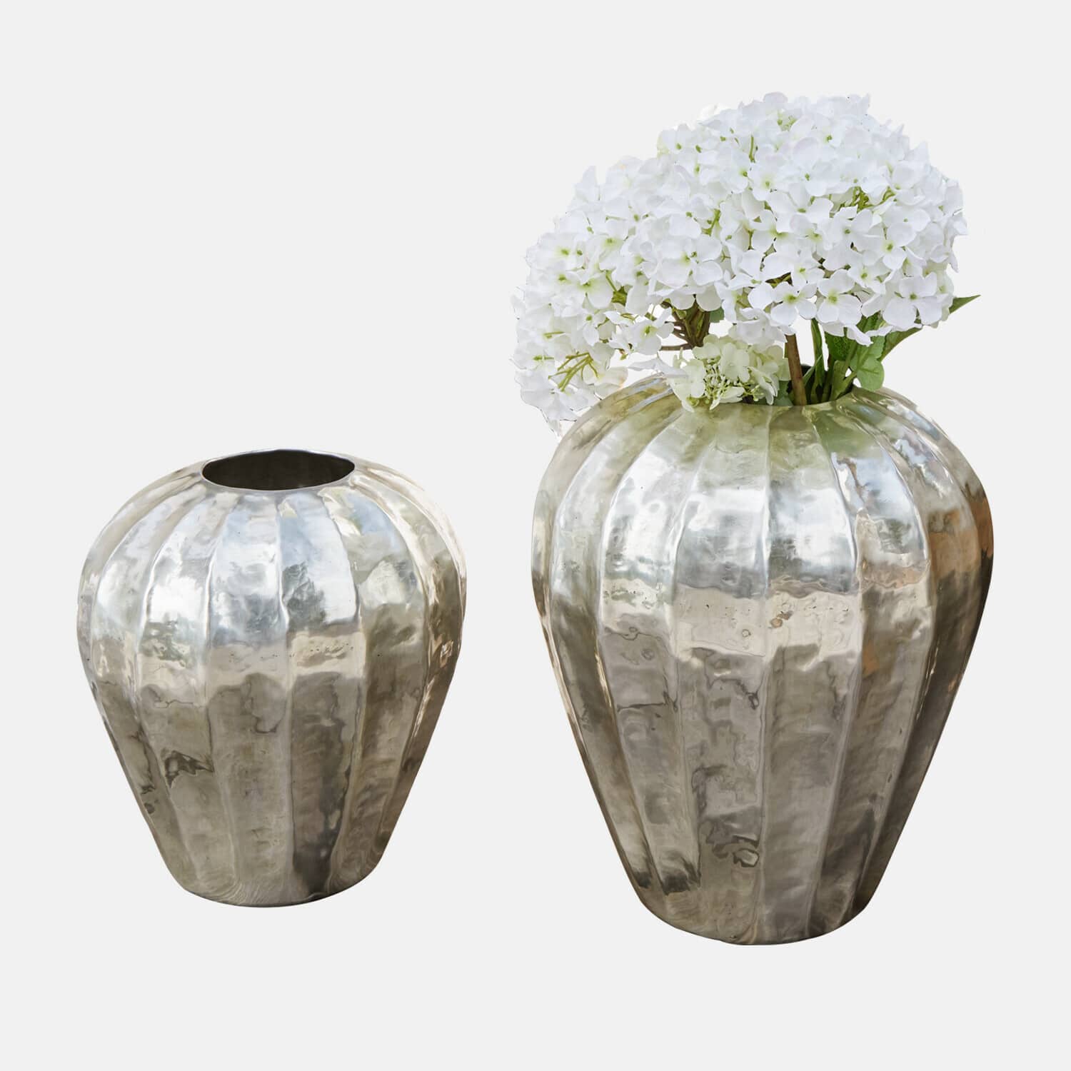 Zwei dekorative Metallvasen in Silber, eine mit weißen Blumen, modernes Design für Wohnraumdekoration