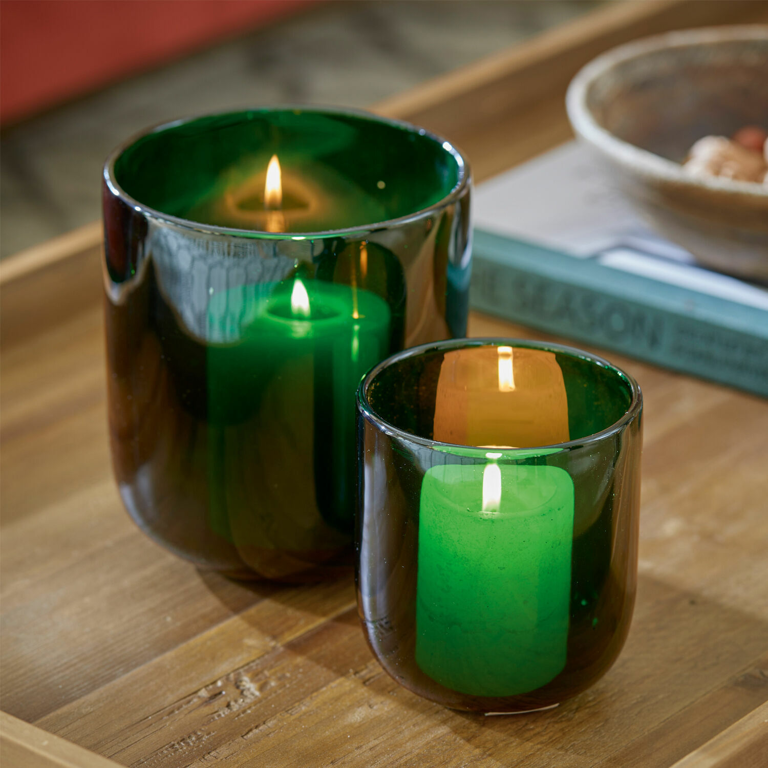Windlicht 2er Set Theodor Zwei grüne Glaswindlichter mit brennenden Kerzen auf Holztisch, stimmungsvolle Wohnraumdeko