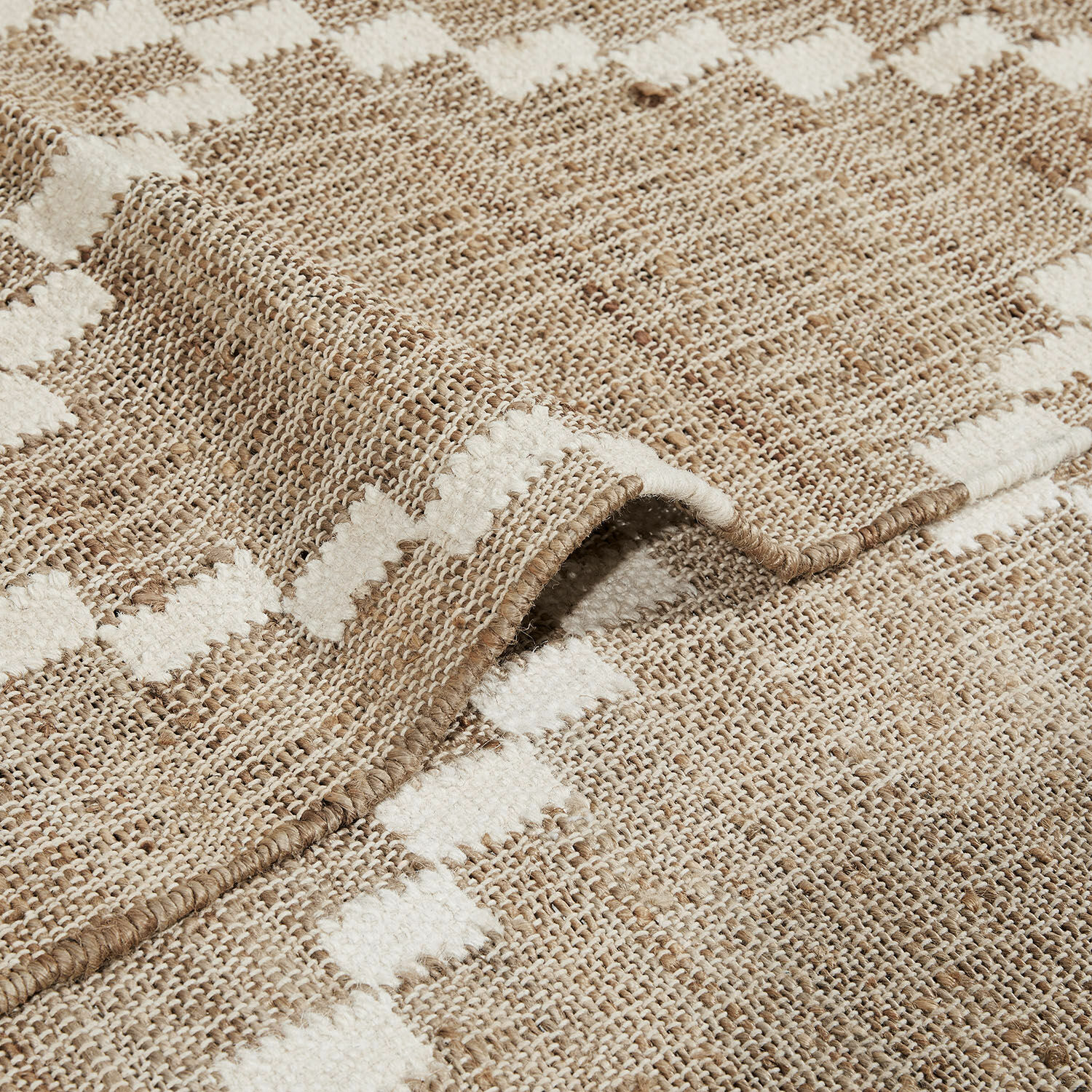 Beiger und weißer Teppich aus Naturmaterial mit geometrischem Muster, ideal für Wohnzimmer