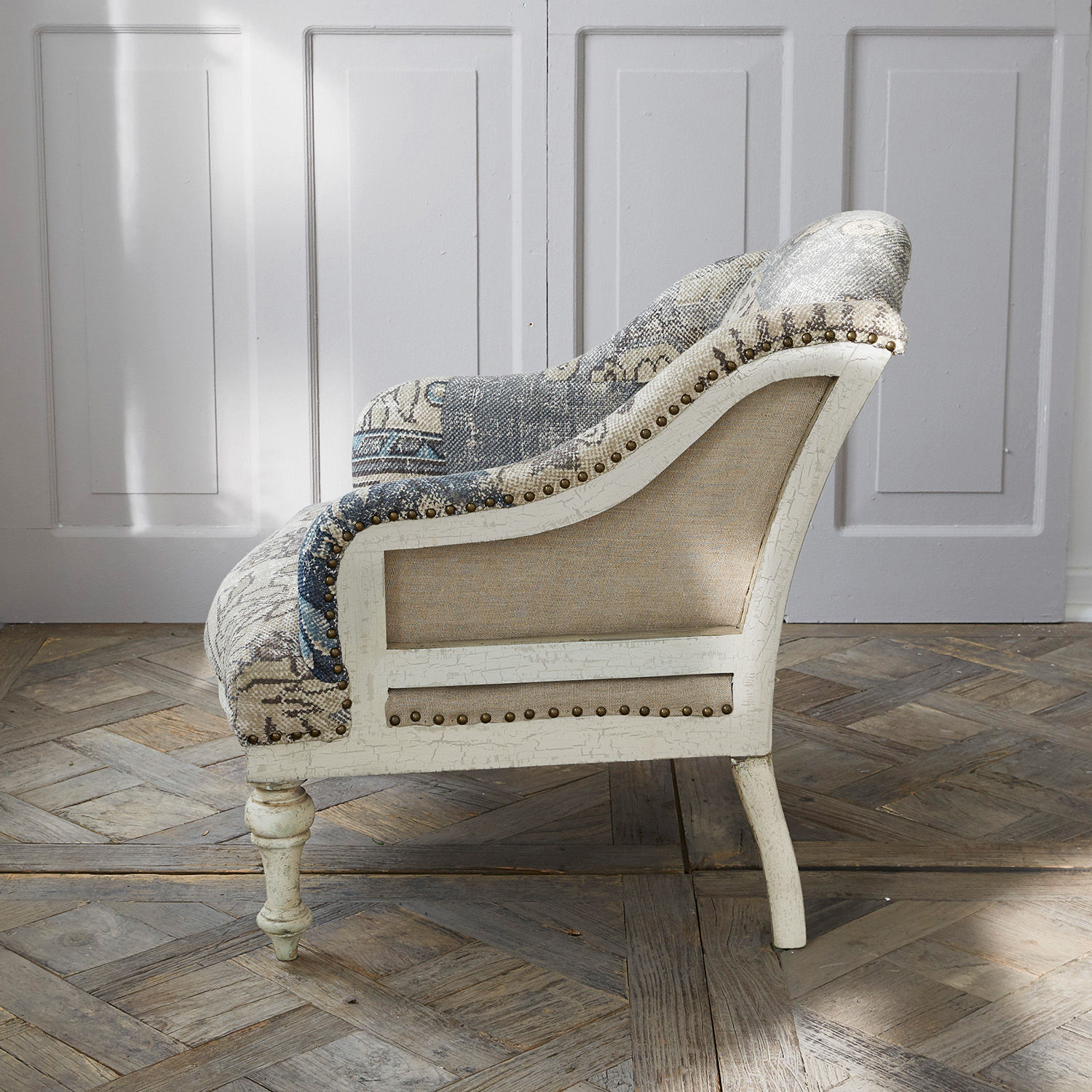 Vintage Sessel aus weißem Holz und blau-beigem Stoff mit dekorativen Nägeln, elegant fürs Wohnzimmer