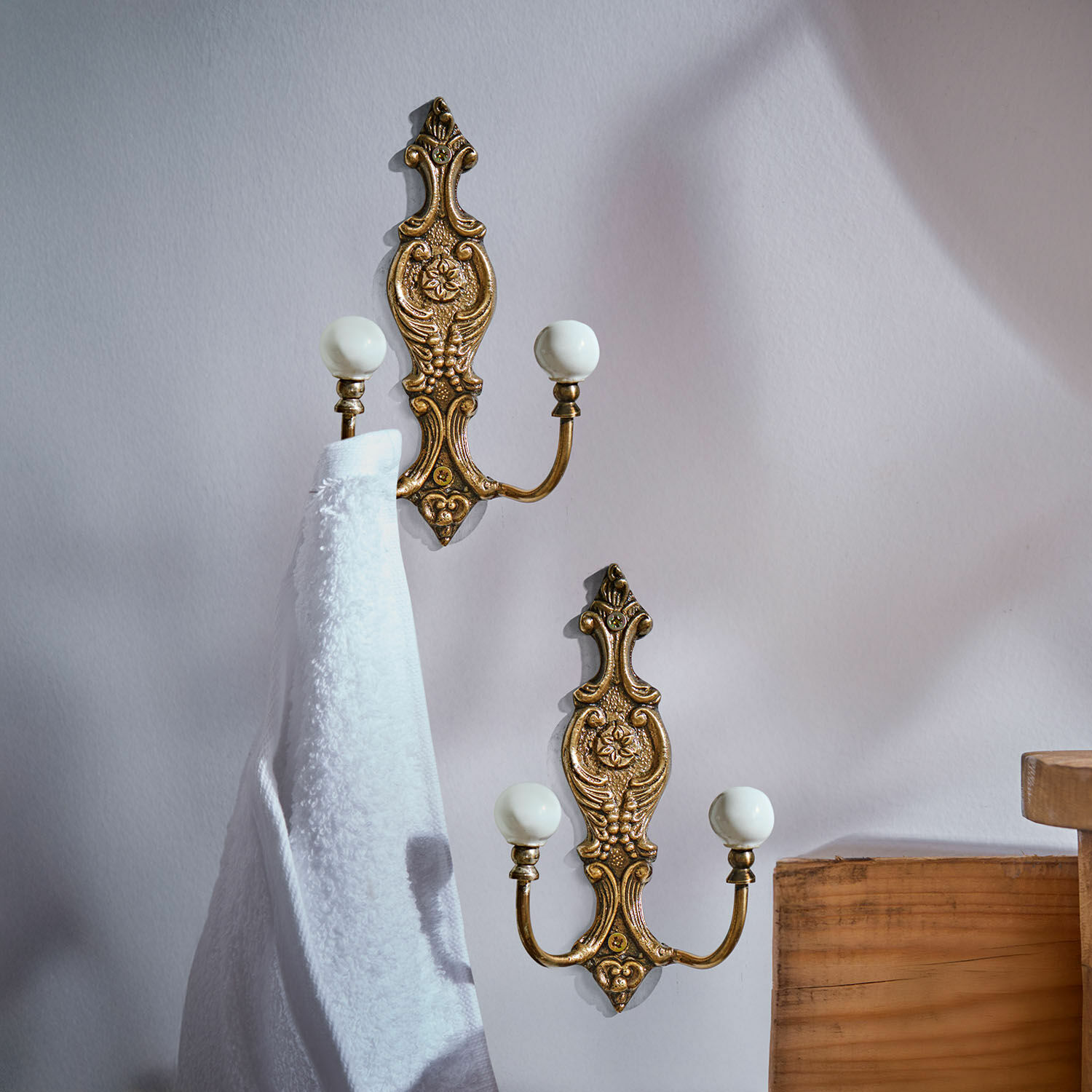 Haken 2er Set Nuvéal Set aus zwei messingfarbenen Wandhaken mit weißen Keramikkugeln und dekorativem Muster