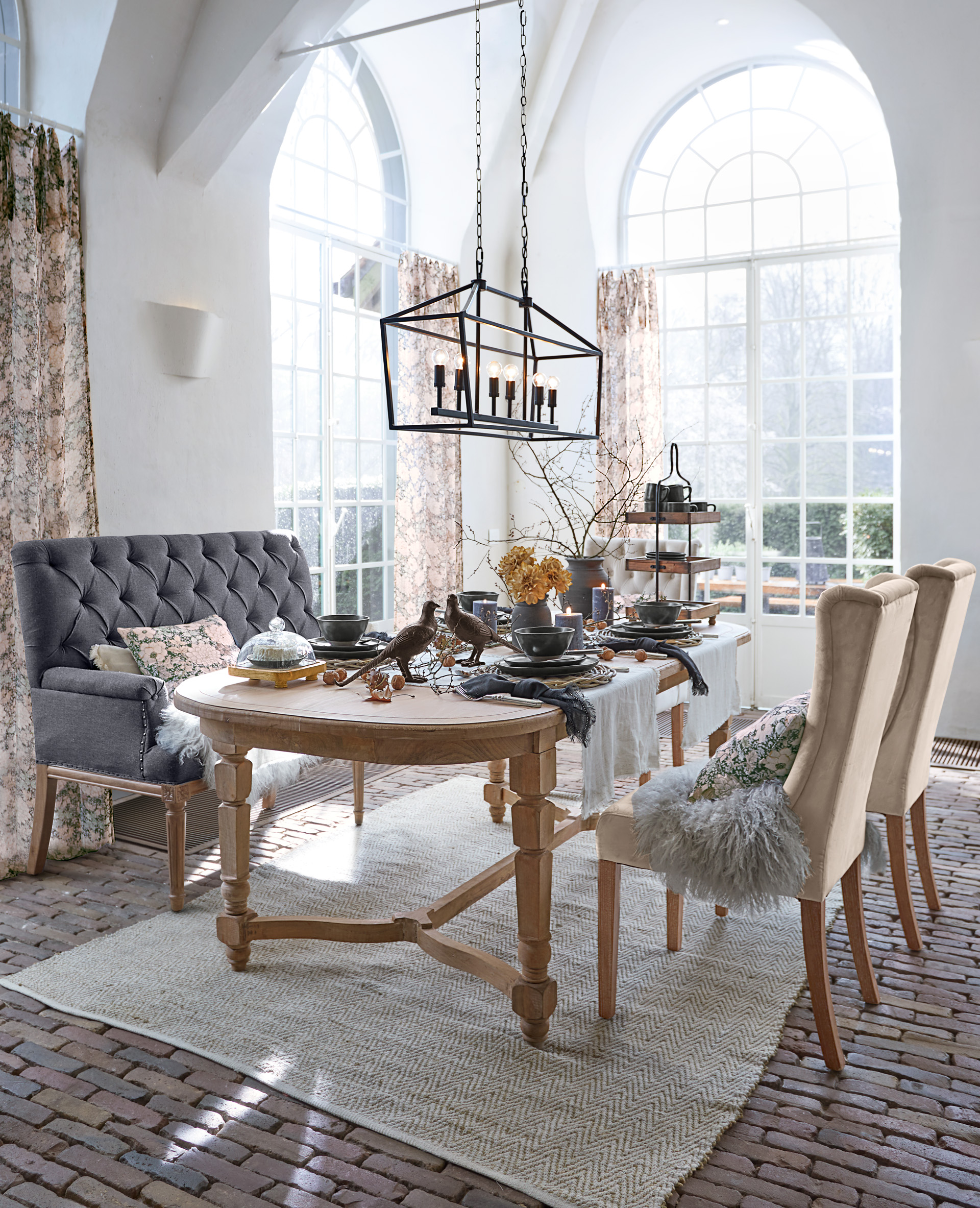 Esszimmer mit Holztisch und gepolsterten Stühlen in Beige und Grau, Tischdekorationen