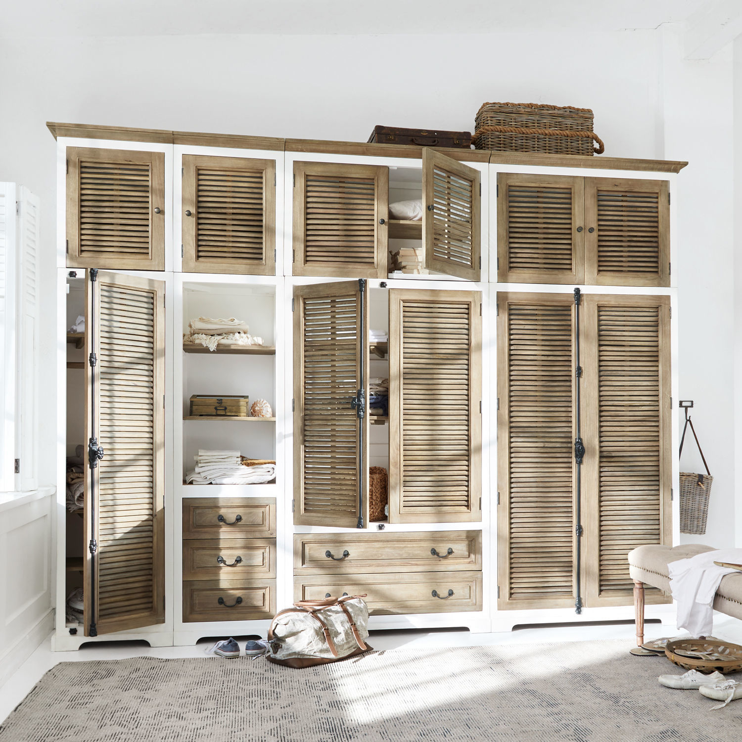 Großer Kleiderschrank aus Holz in Natur- und Weißtönen mit Lamellentüren und Schubladen zur Aufbewahrung