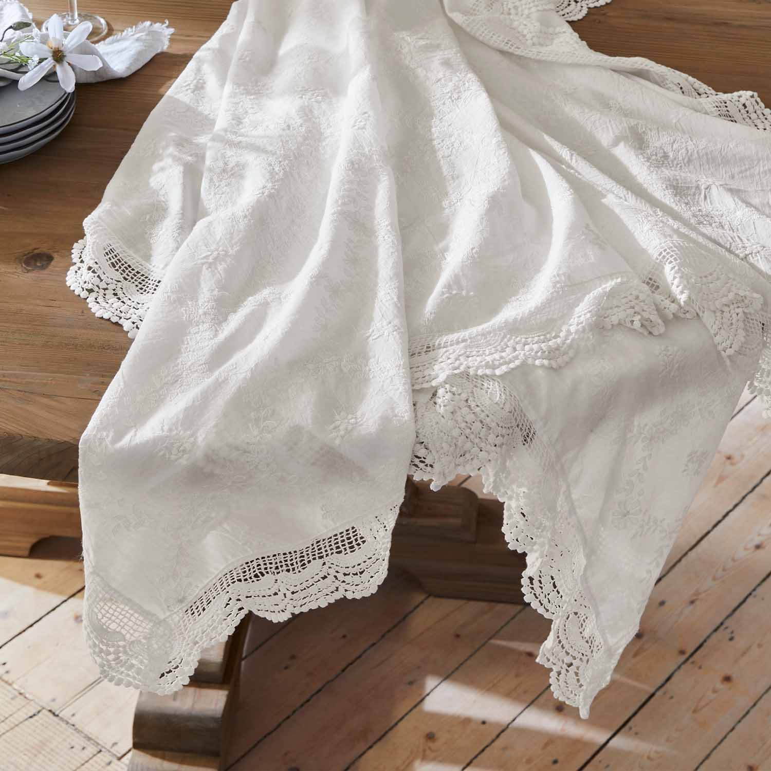 Weißer bestickter Tischläufer mit Spitzenrand auf Holztisch, elegante Tischdekoration