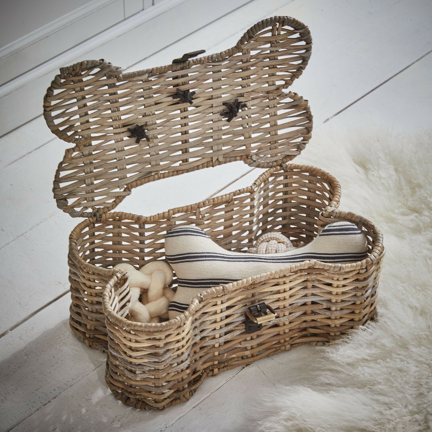Korb Nuzzlea Rattankorb in Knochenform mit Hundespielzeug in Naturfarbe auf weißem Boden