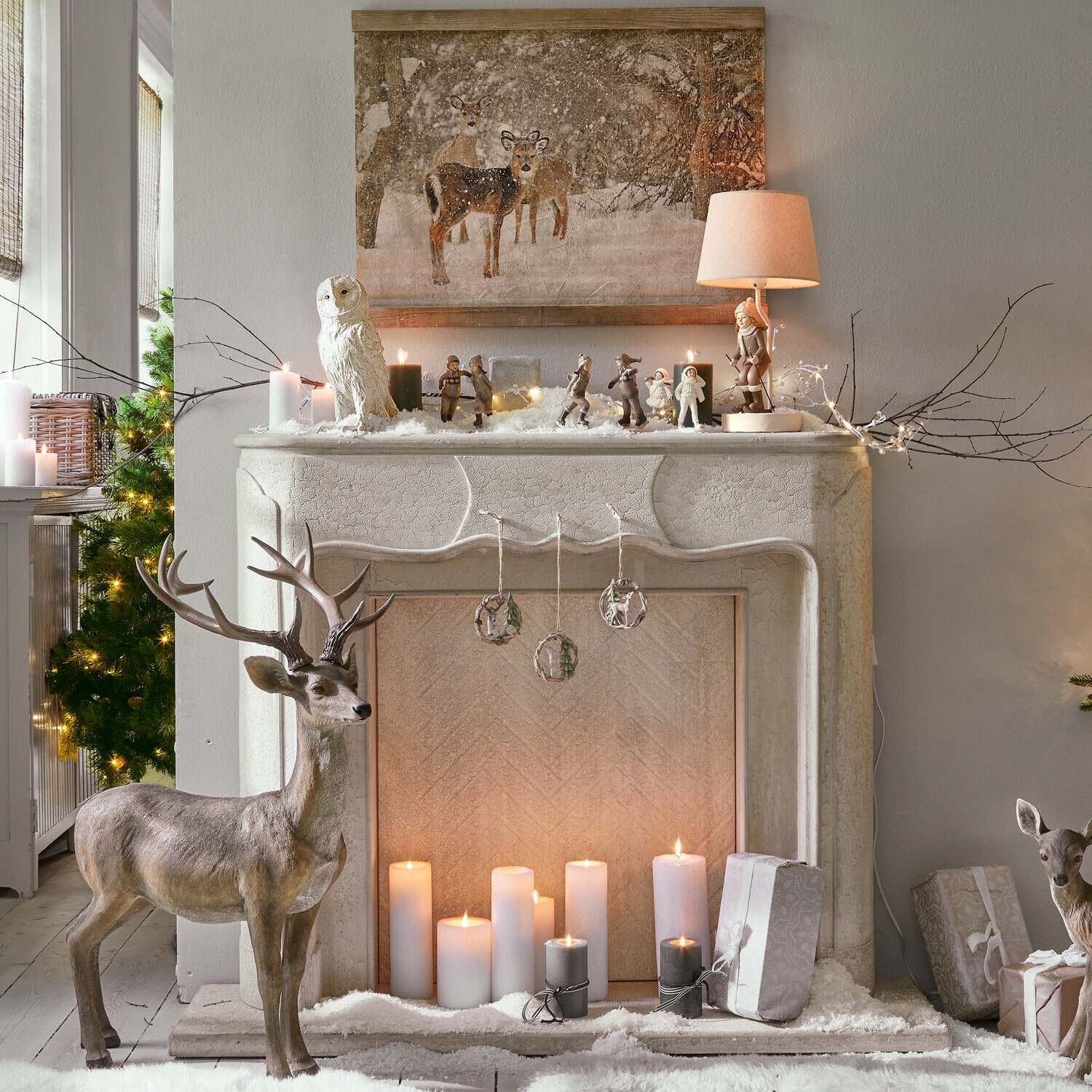 Dekorativer Kamin mit weißen Kerzen, Tierfiguren und winterlichen Weihnachtsdekorationen