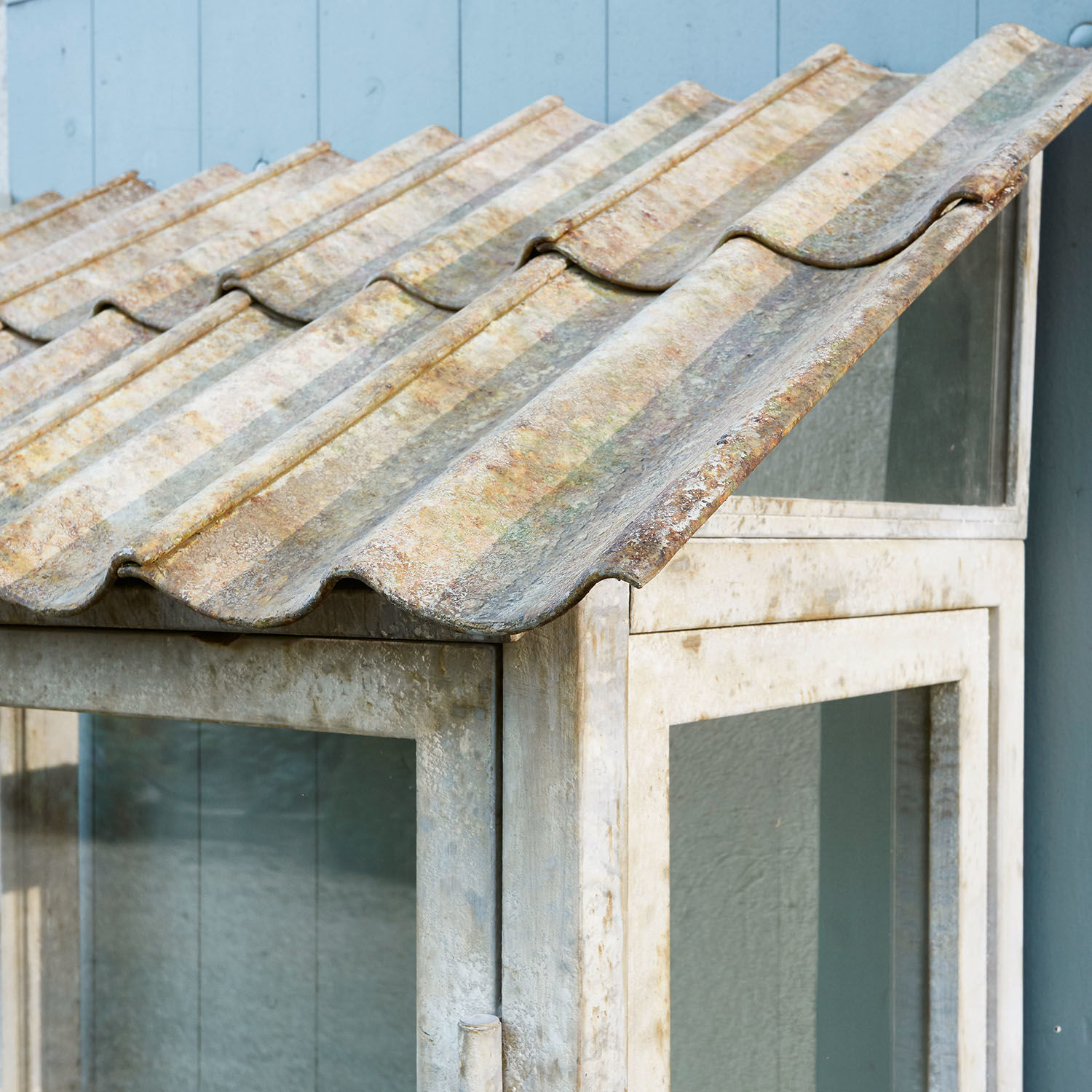 Metall-Glas-Schrank mit welligem, gealtertem grauem Dach für den Gartenbereich