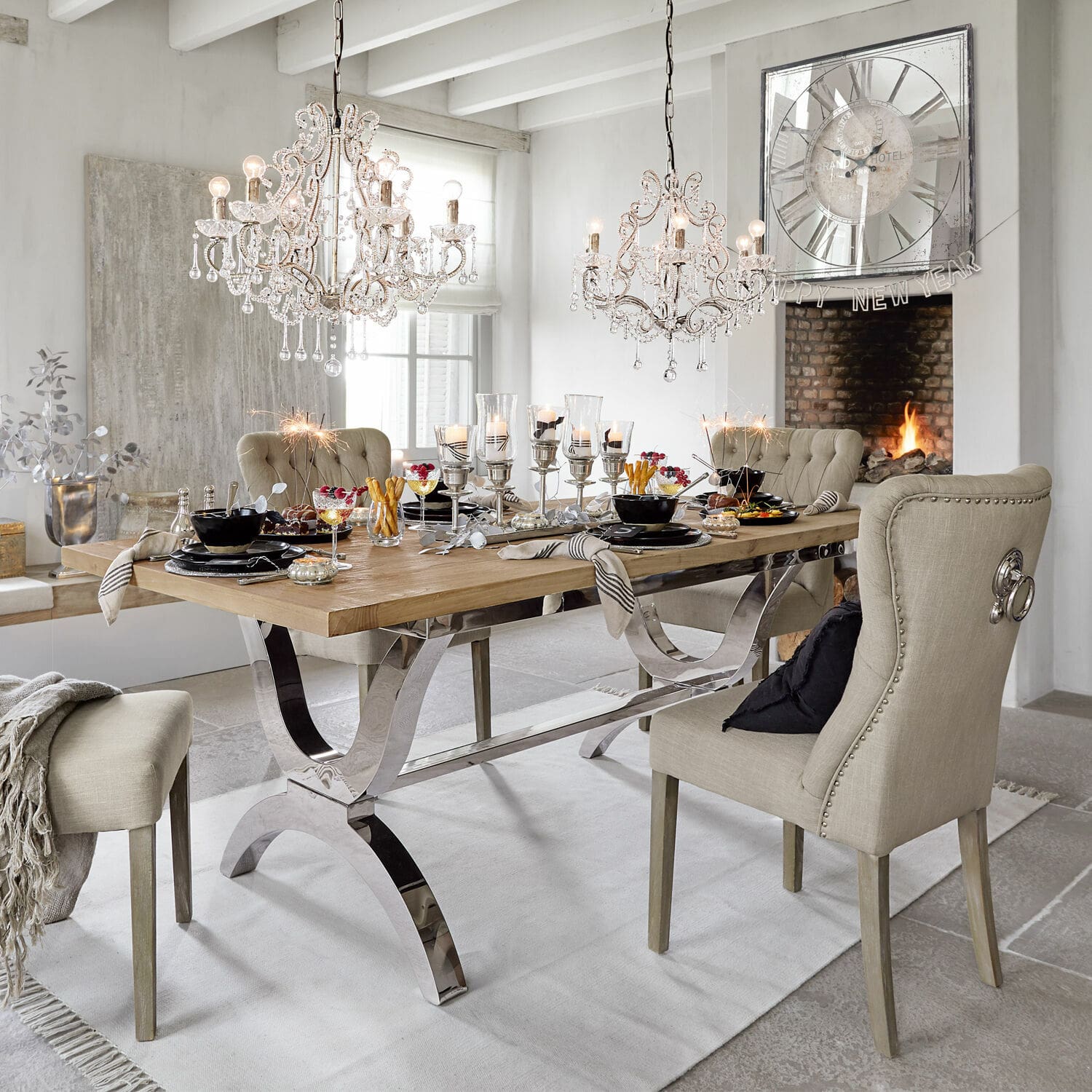 Tisch Grover Esszimmer mit Holztisch und beige gepolsterten Stühlen, Dekorationen und Kristall-Kronleuchtern