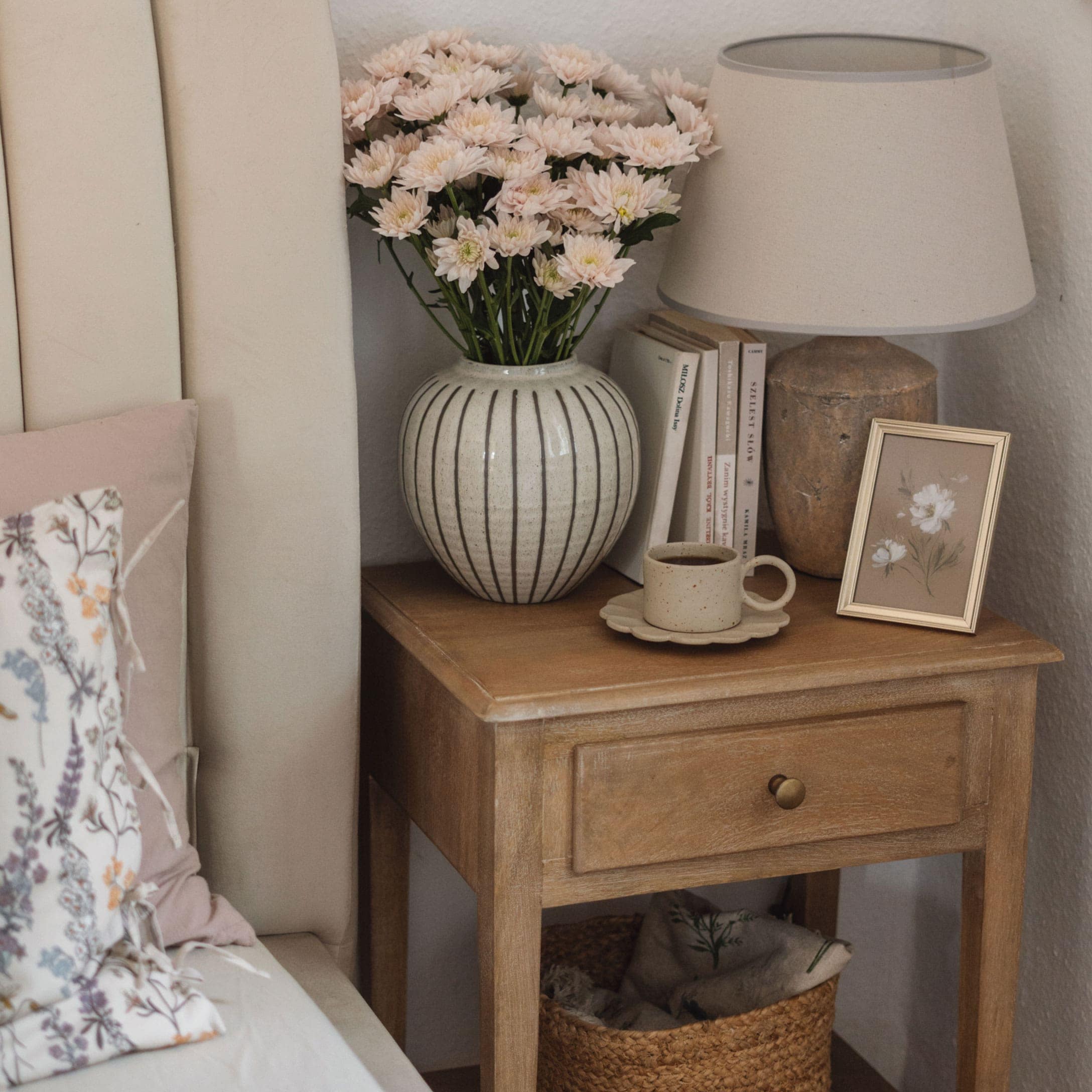 Holz-Nachttisch mit gestreiftem Keramikvase, Blumen, Lampe und Kaffeetasse in Beige