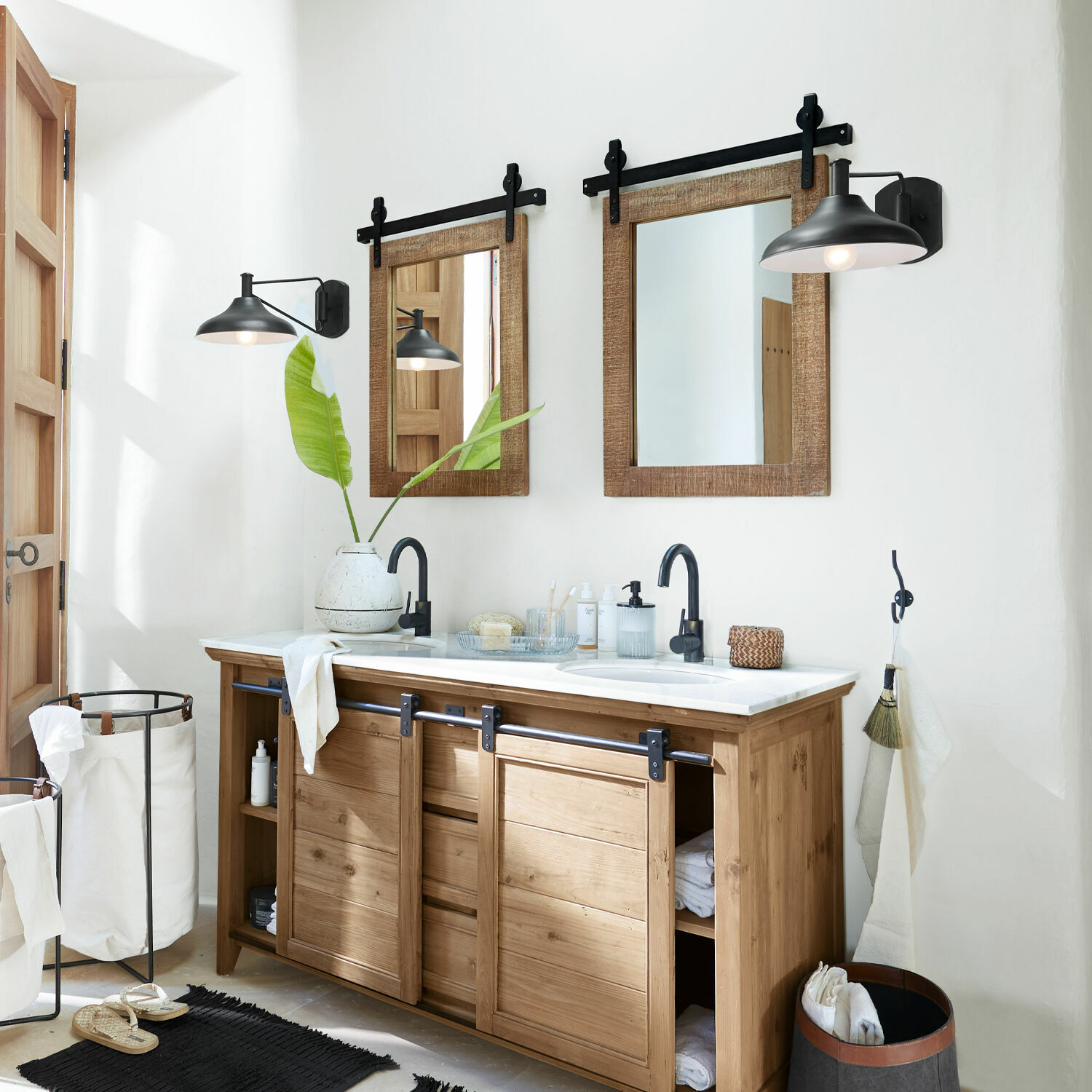 Holz-Badezimmerschrank mit weißer Arbeitsplatte, zwei rustikale Spiegel und schwarze Wandleuchten