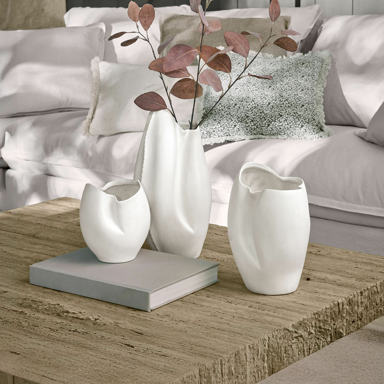 Vase 3er Set Kazimad Drei weiße Keramikvasen mit unregelmäßiger Form auf einem Holztisch im Wohnzimmer