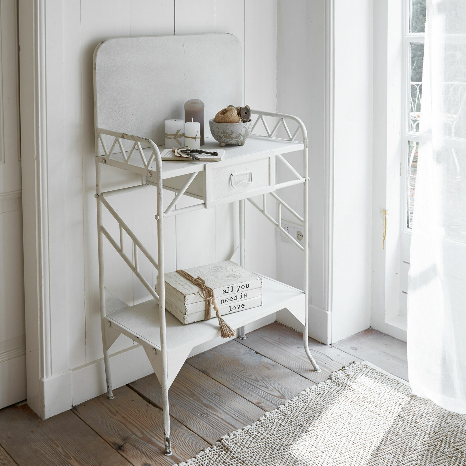 Weißer Metalltisch mit Schublade und Ablage, dekoriert mit Kerzen und Büchern im Vintage-Stil