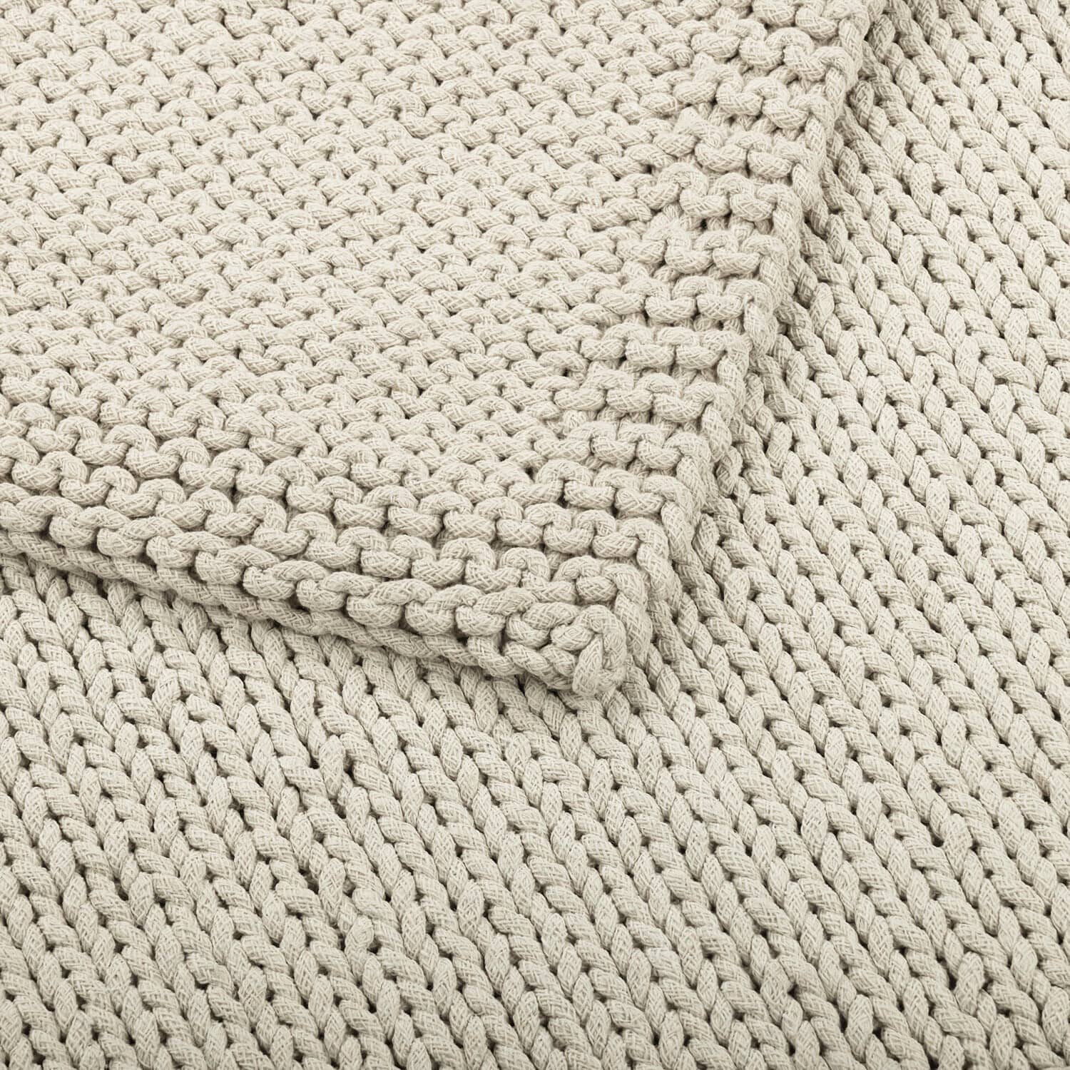 Dicker, beige gestrickter Baumwollplaid mit dekorativem Muster, ideal für gemütliche Räume