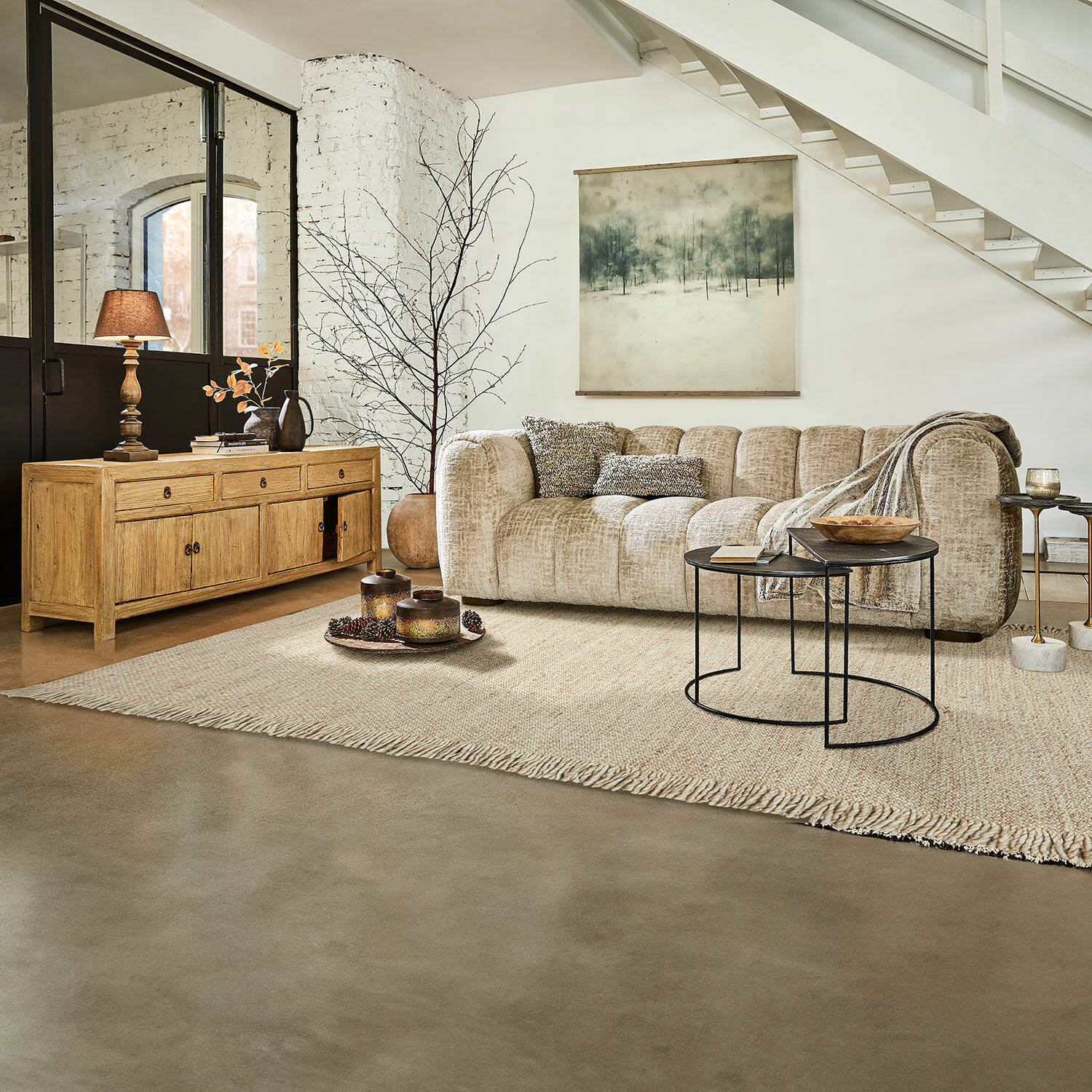 Teppich Levraut Beiges Stoffsofa in modernem Wohnzimmer mit Holzkommode und schwarzen Metall-Couchtischen