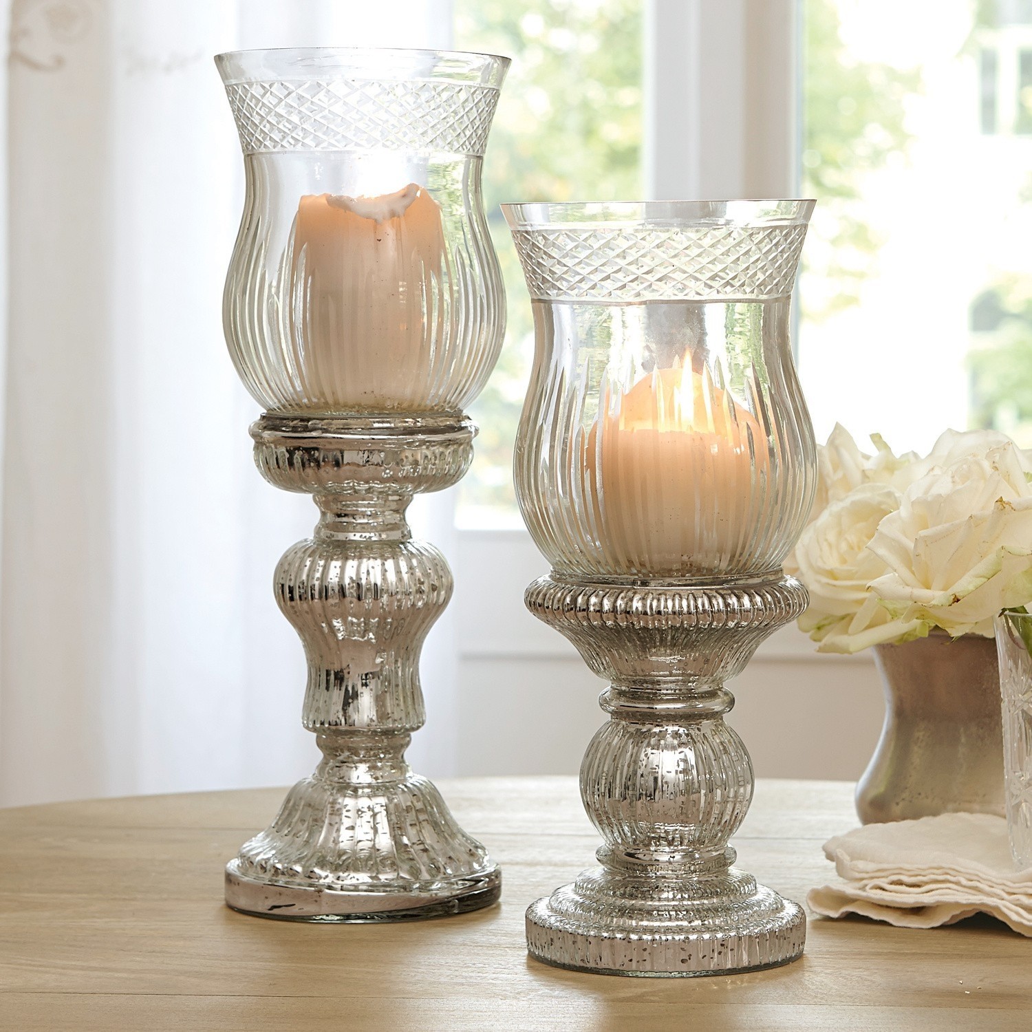 Kerzenständer 2er Set Luisant Zwei dekorative Kerzenhalter aus Glas mit antik-silbernem Effekt auf Holztisch in hellem Raum