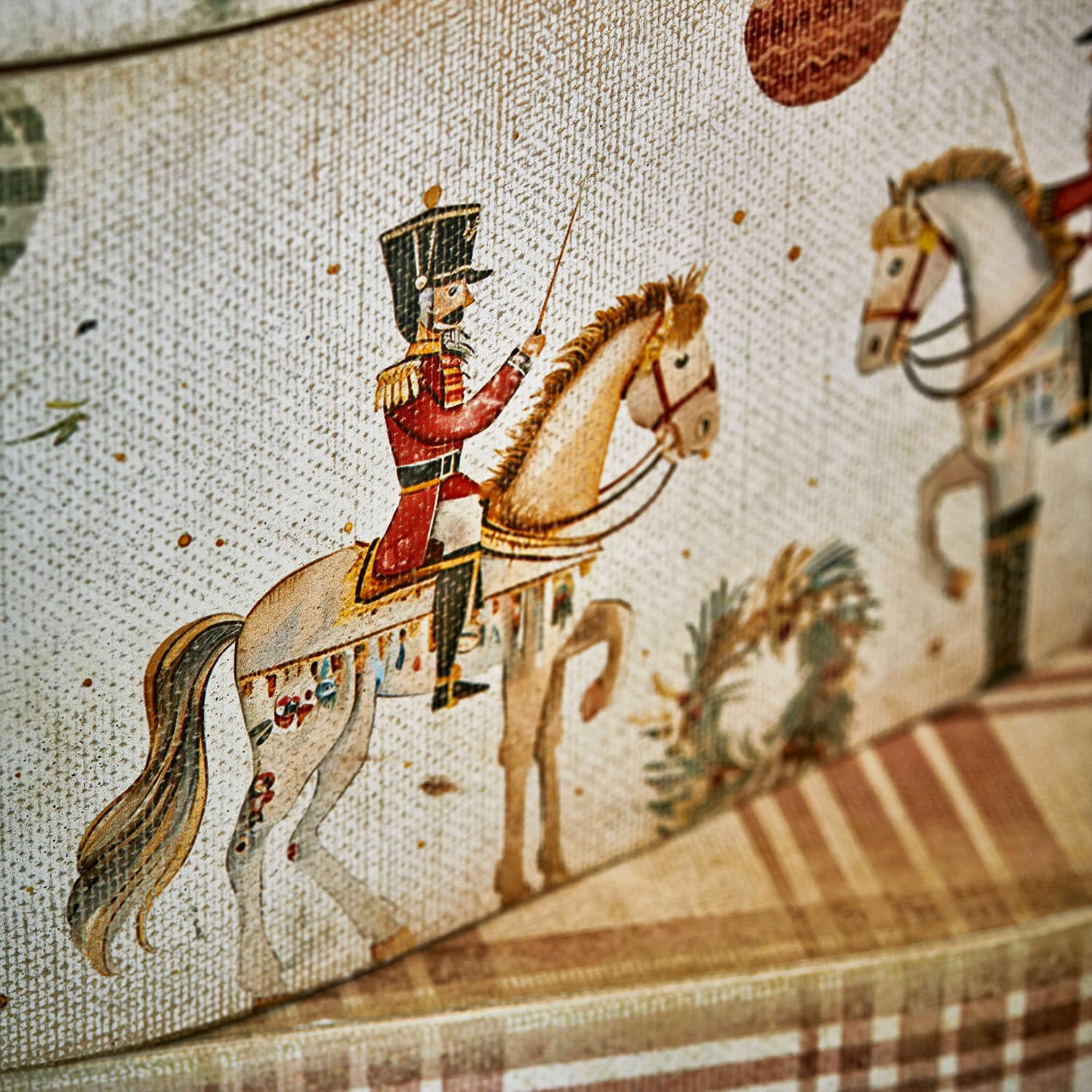 Detailaufnahme eines dekorativen Stoffes mit Soldat auf Pferd in rotem Uniformmantel