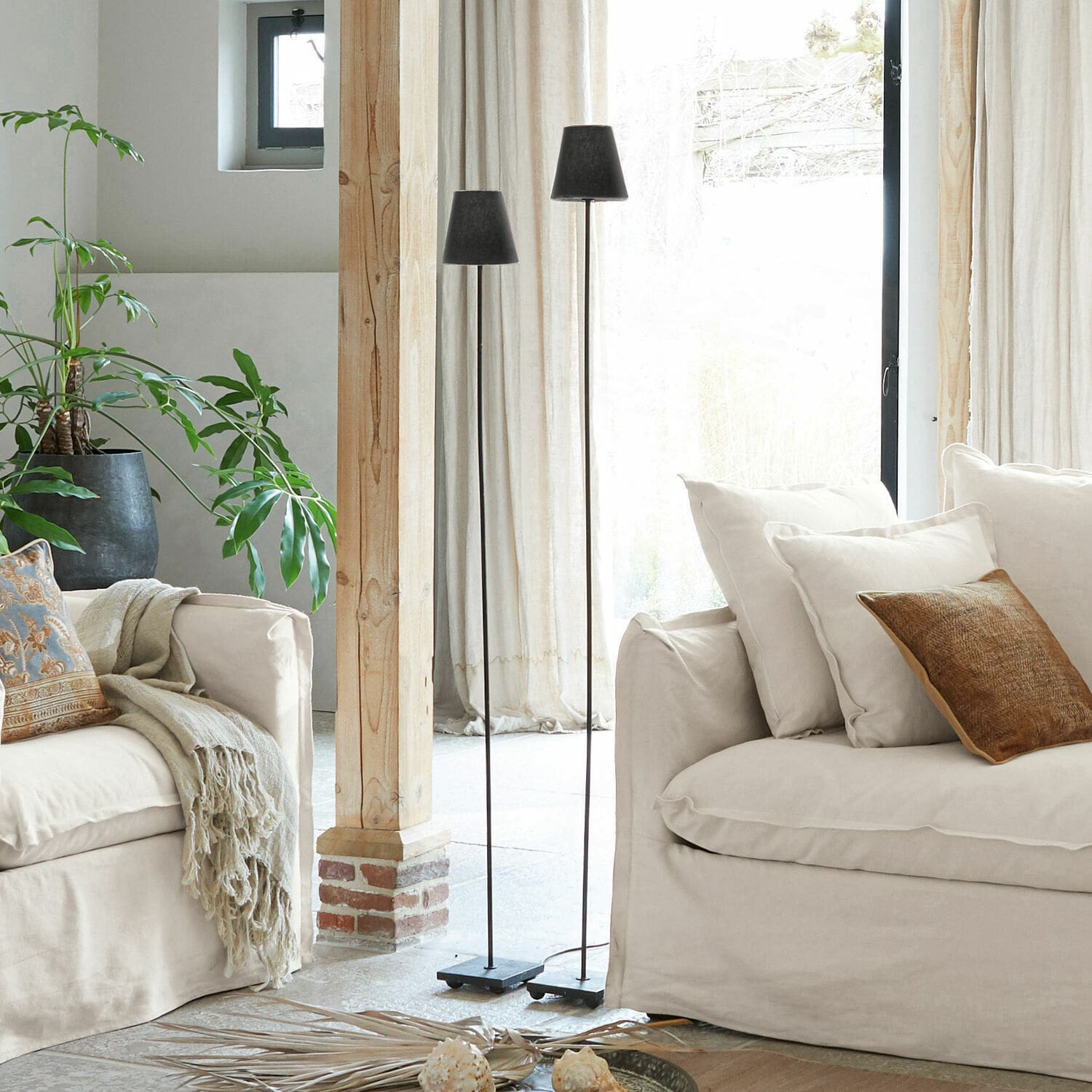 Stehlampe 2er Set Tacoma Zwei schwarze Metall-Stehlampen im hellen Wohnzimmer mit beigem Sofa und grüner Pflanze