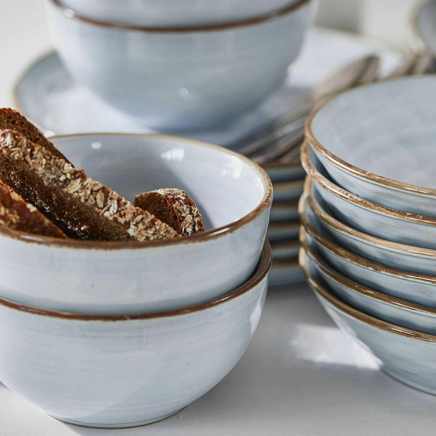 Set aus hellblauen Keramikschalen mit braunem Rand, ideal zum Servieren von Snacks