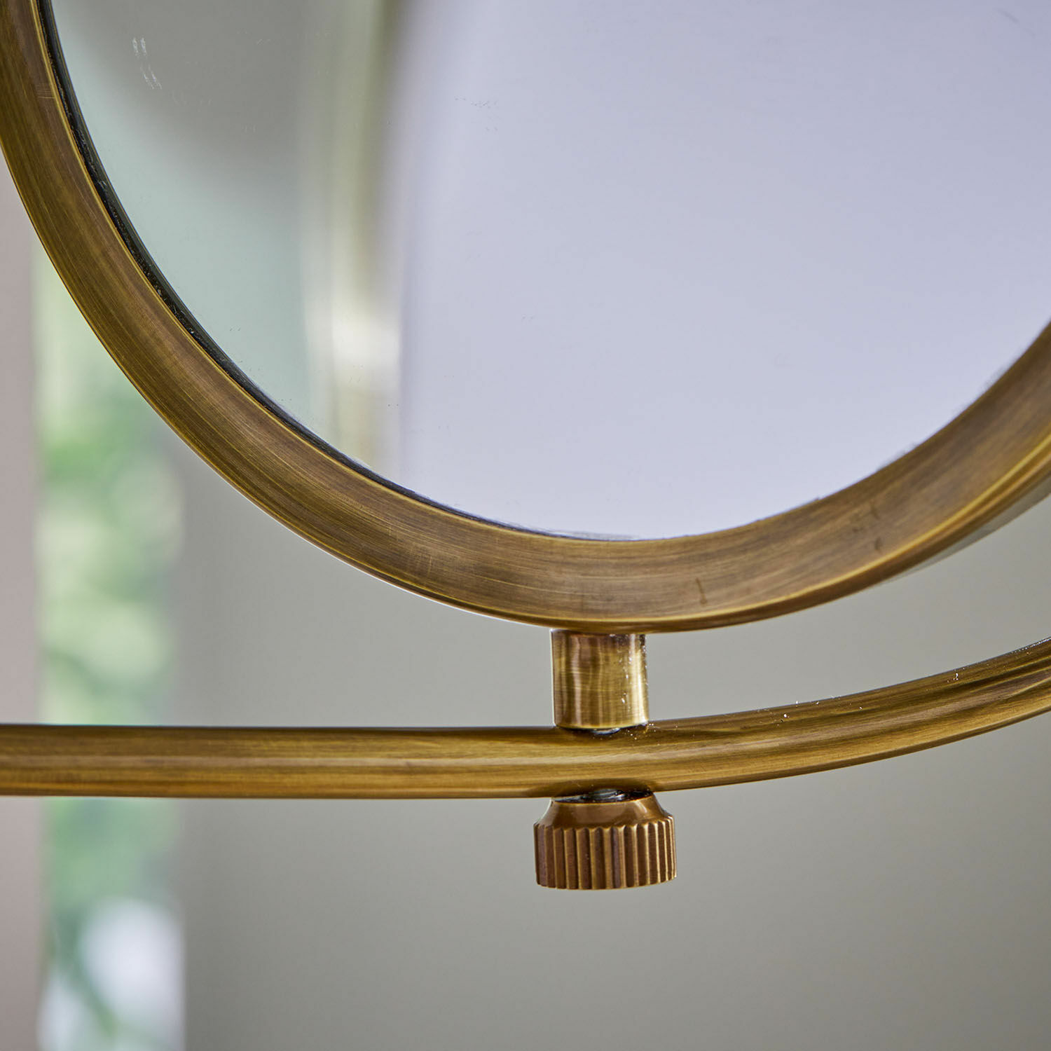 Goldfarbener Metallrahmen eines Spiegels mit verstellbarem Drehknopf, Deko-Element