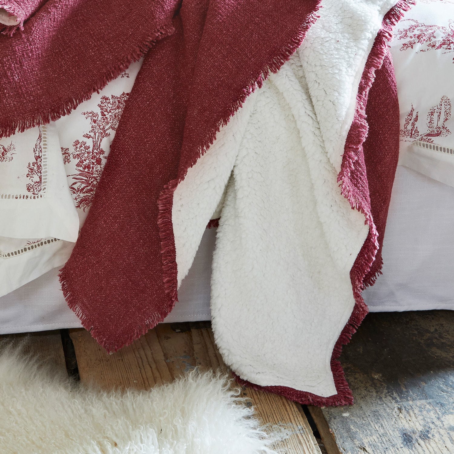 Wendedecke in Bordeaux mit weißem, weichem Teddyfleece auf Holzboden liegend