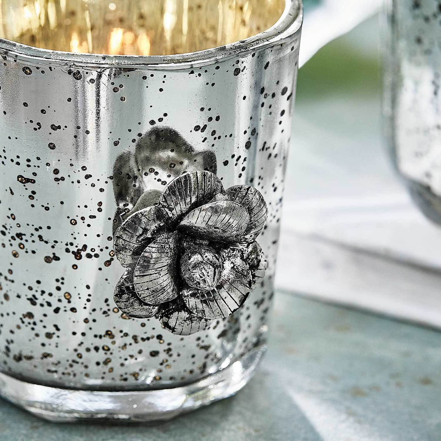 Silberner Glas-Teelichthalter mit Metallblume und antiker Oberfläche für Wohnraumdeko