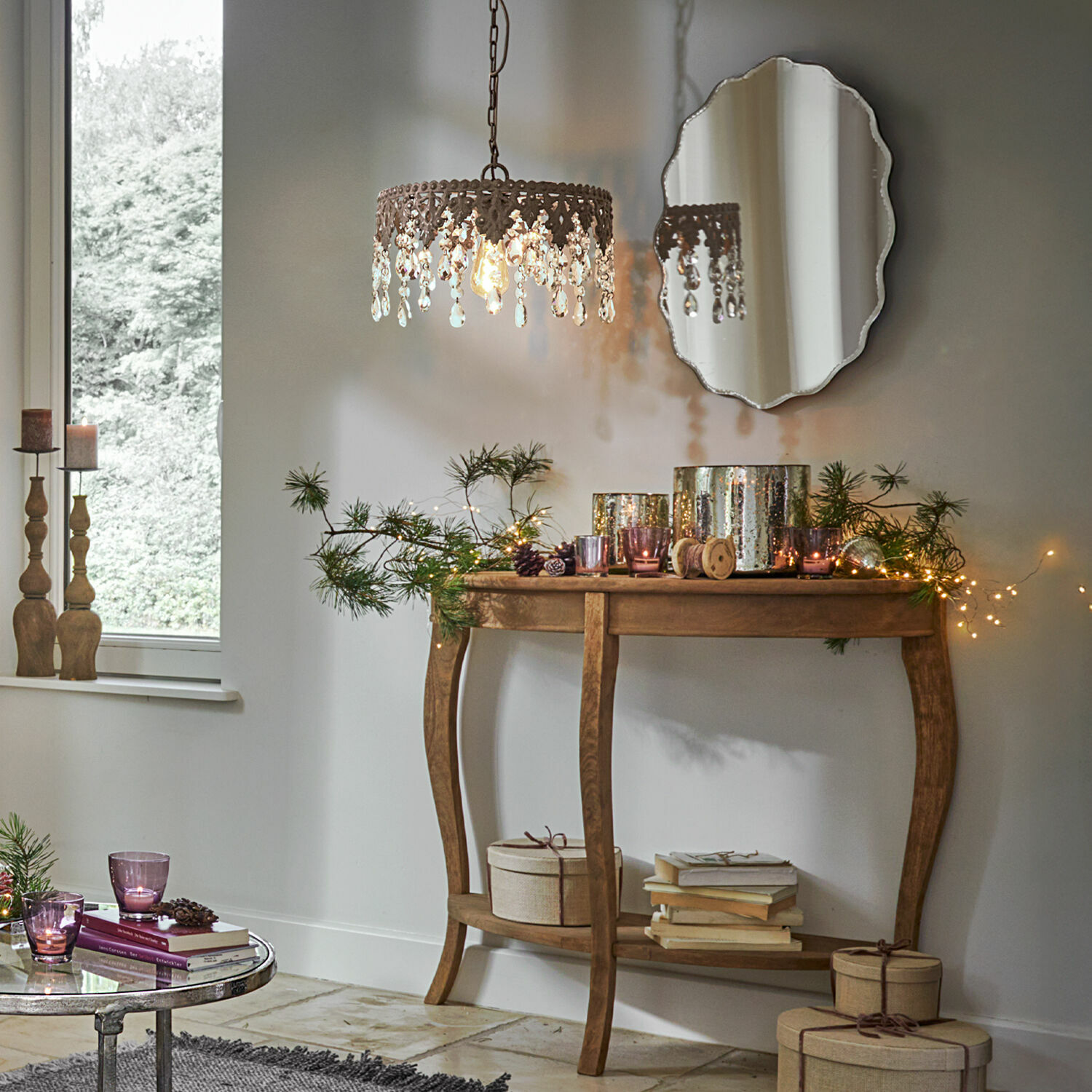 Holzkonsole mit Weihnachtsdekoration und Kristall-Hängeleuchte in gemütlichem Raum