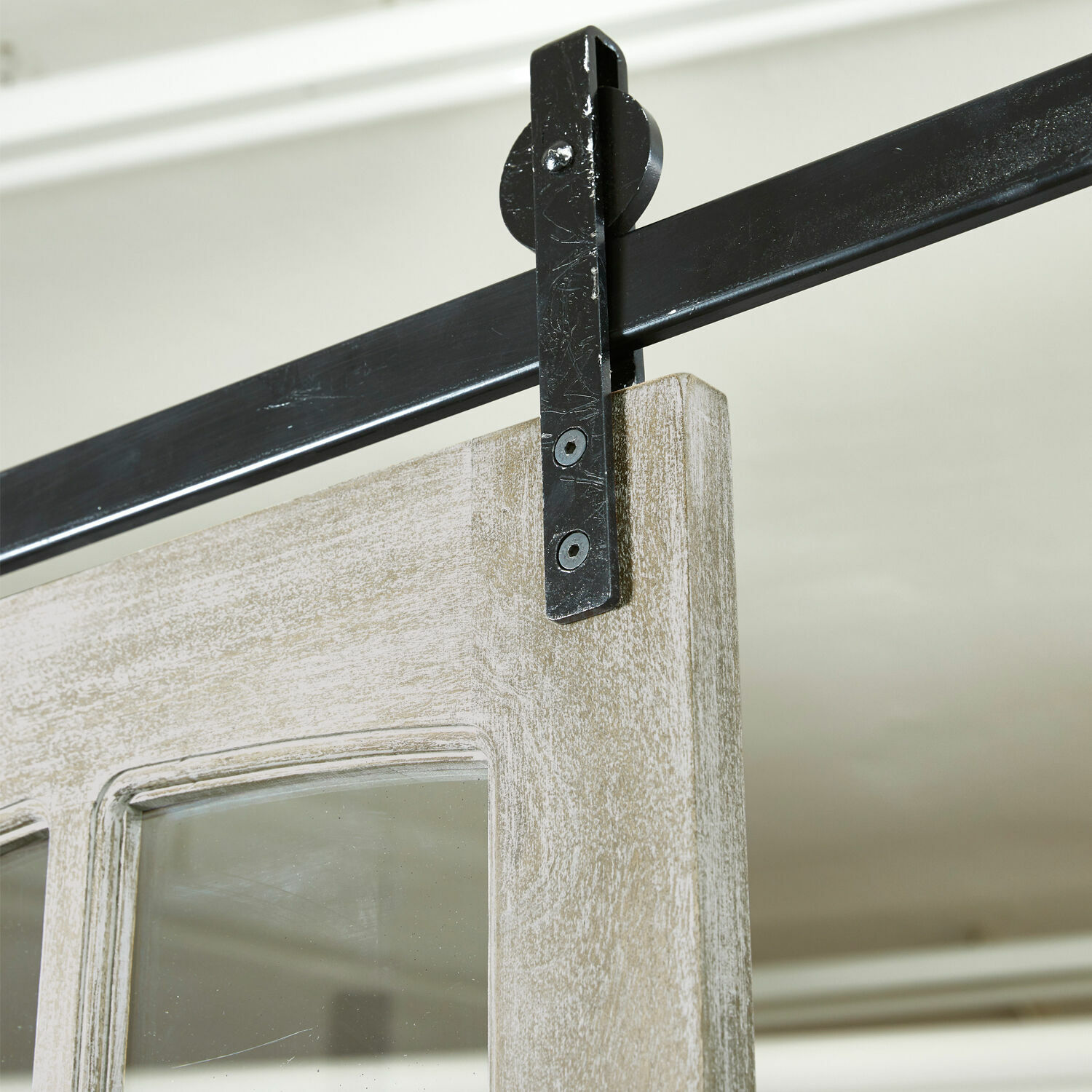 Schiebetür aus hellem Holz mit schwarzem Metallgriff und Laufschiene für Innenräume