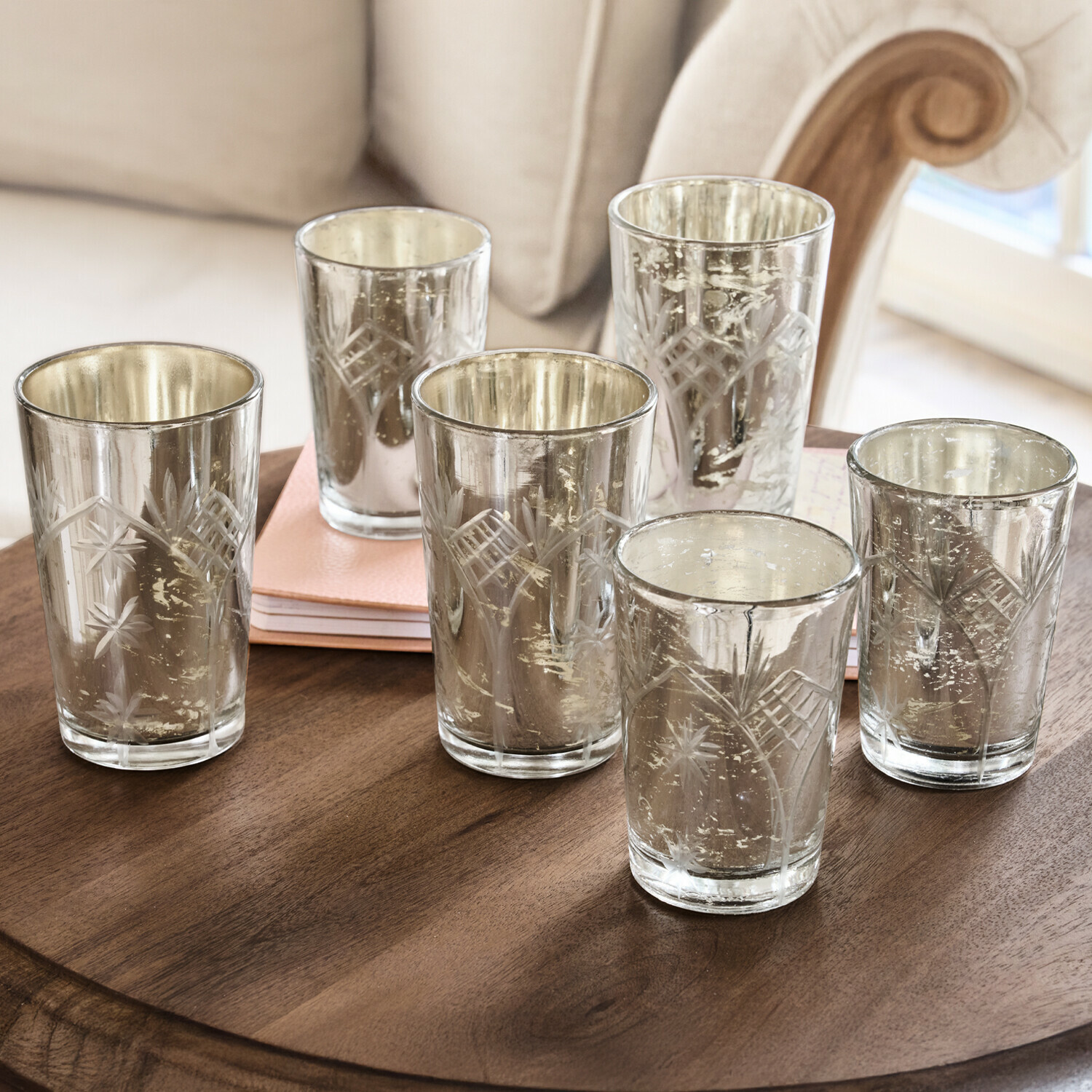 Set aus sechs gravierten Glas-Teelichthaltern mit silberner Innenbeschichtung auf Holztisch