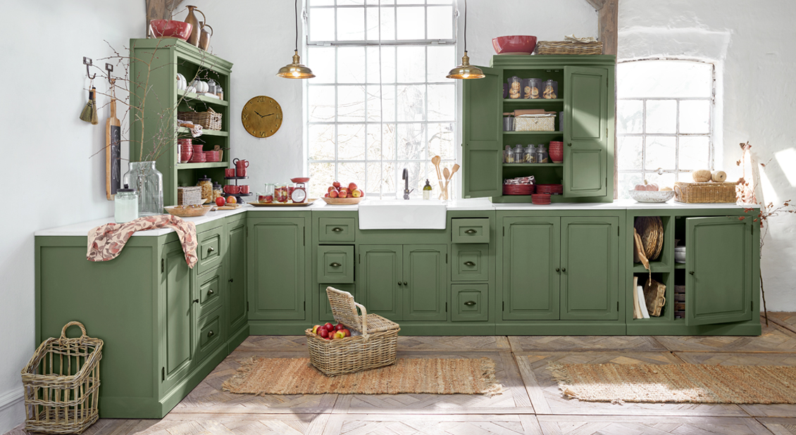 Landhausküche mit grünen Holzschränken und weißer Arbeitsplatte, viel natürliches Licht