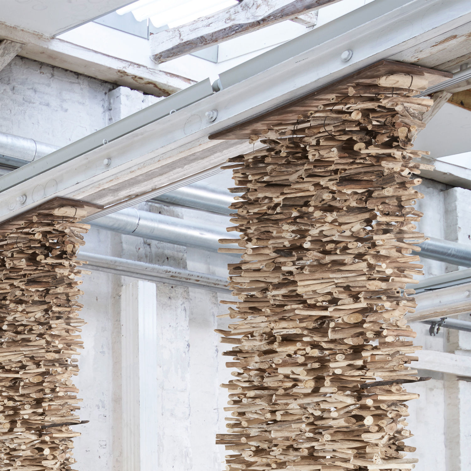 Dekorative Säule aus hellem Naturholz in modernem Industrieambiente