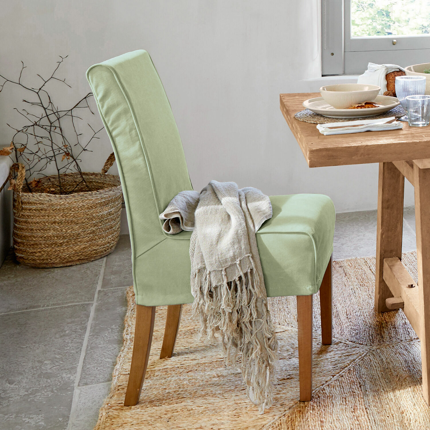 Stuhl mit Husse Mankato Hellgrüner Polsterstuhl mit Holzbeinen und beigem Plaid im Esszimmer mit Naturteppich