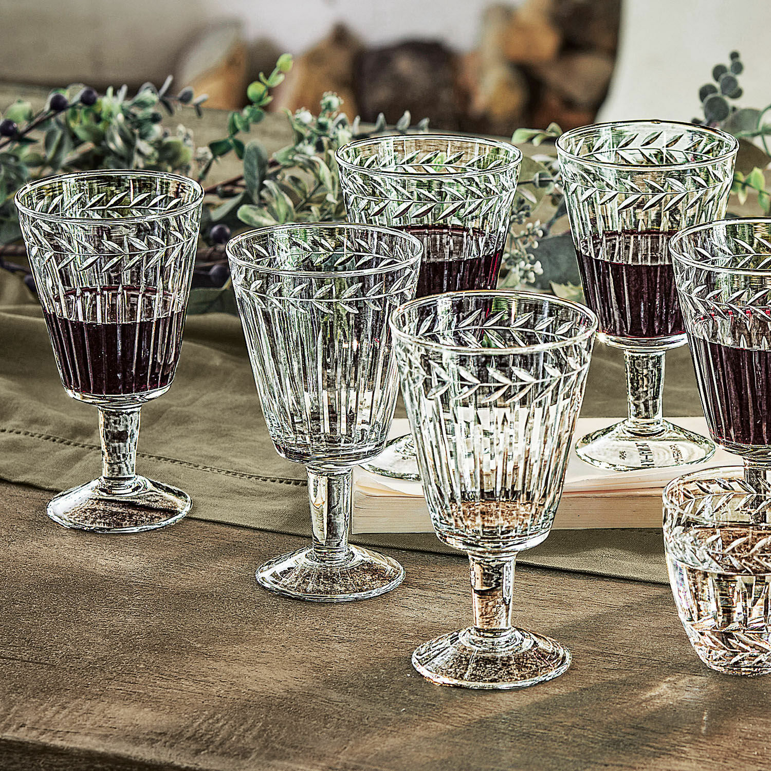 Sechsteiliges Set Gläser aus klarem Glas mit Blattmuster, teilweise mit Rotwein gefüllt