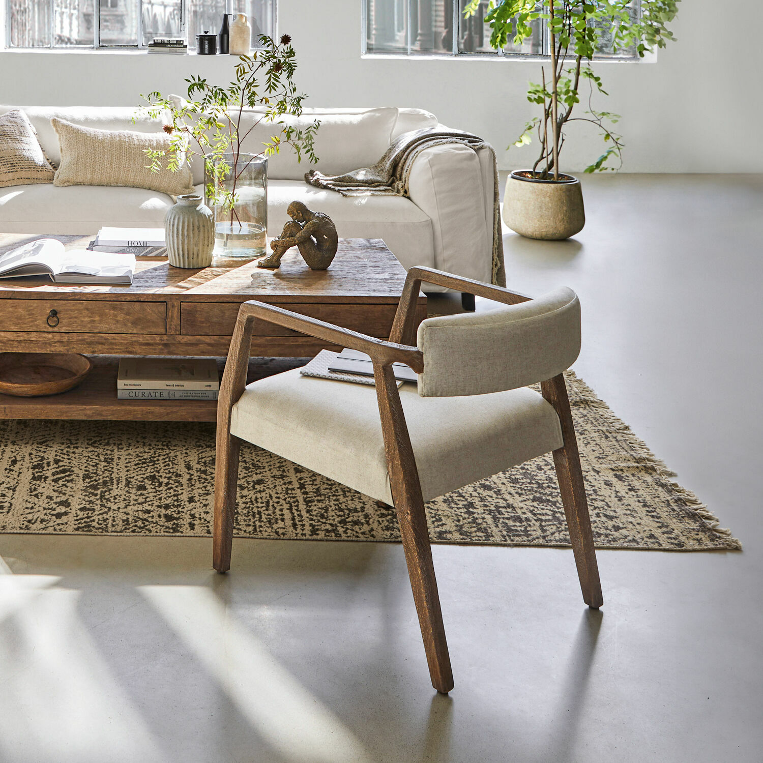 Moderner Stuhl mit Holzrahmen und beigem Stoffbezug in hellem Wohnzimmer mit Teppich und Holztisch