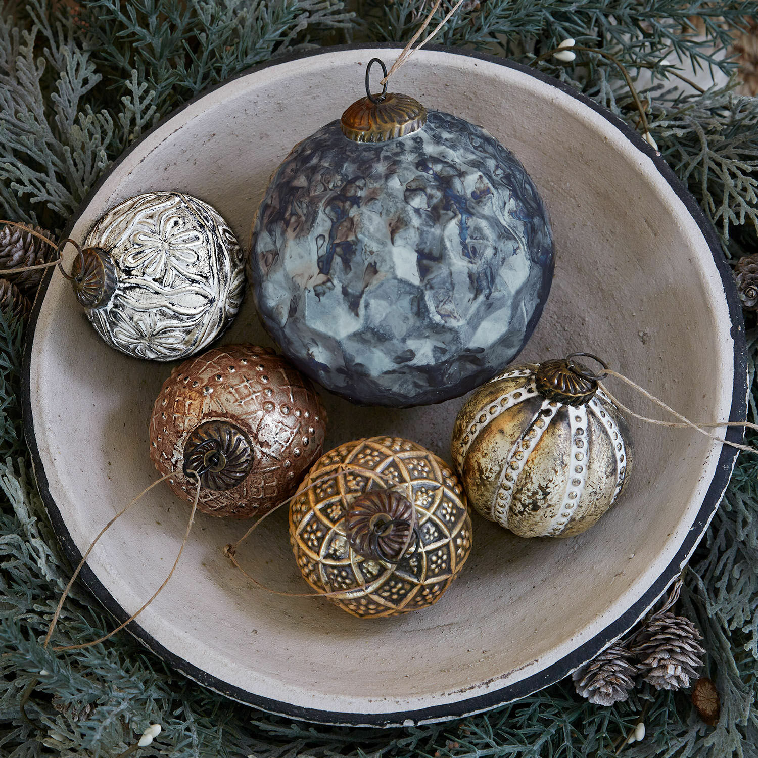 Weihnachtsschmuck 5er Set Jilian Dekorative Weihnachtskugeln aus Metall in verschiedenen Farben in Keramikschale auf grünem Hintergrund