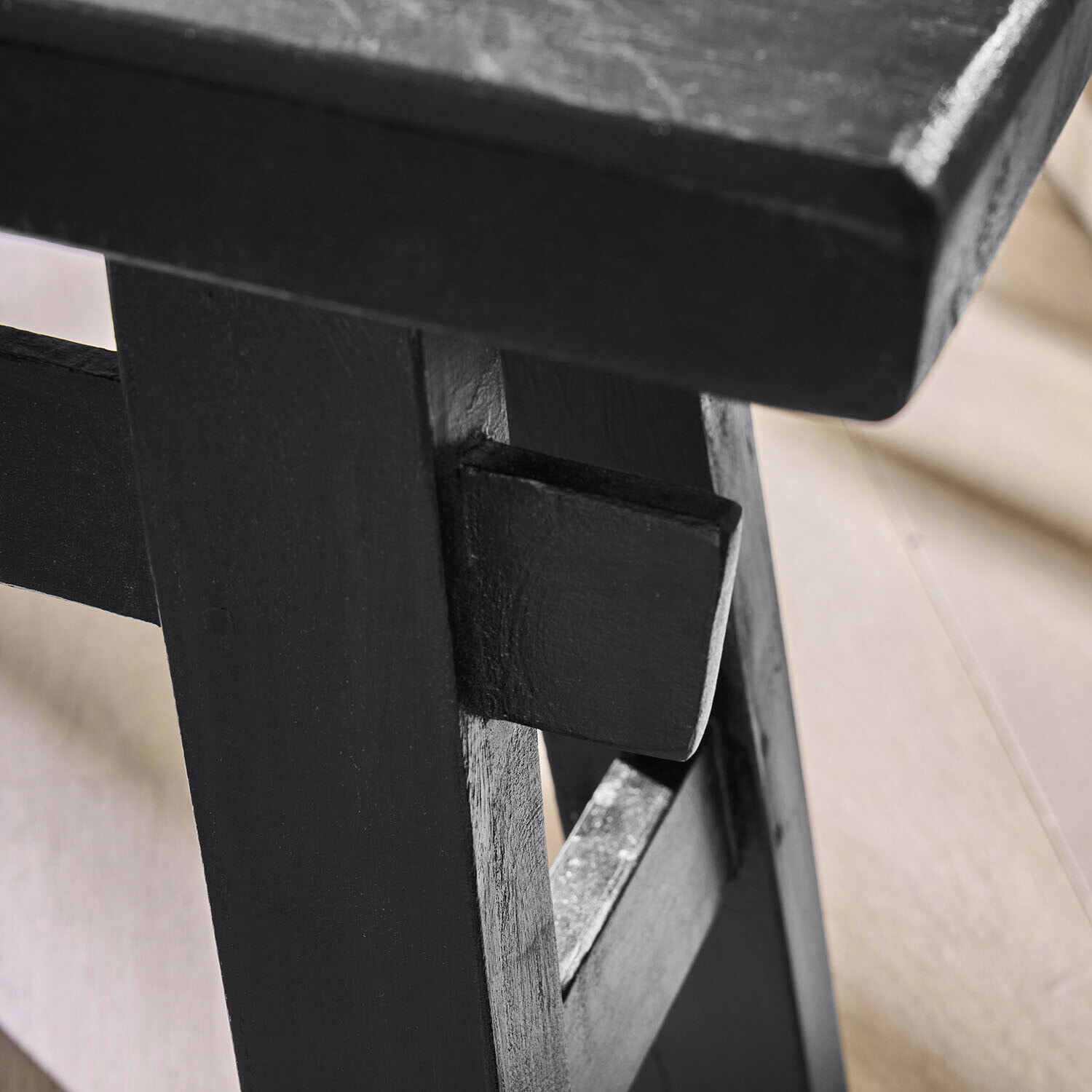 Schwarzer Holztisch mit sichtbarem Verbindungsdetail und natürlicher Holzstruktur